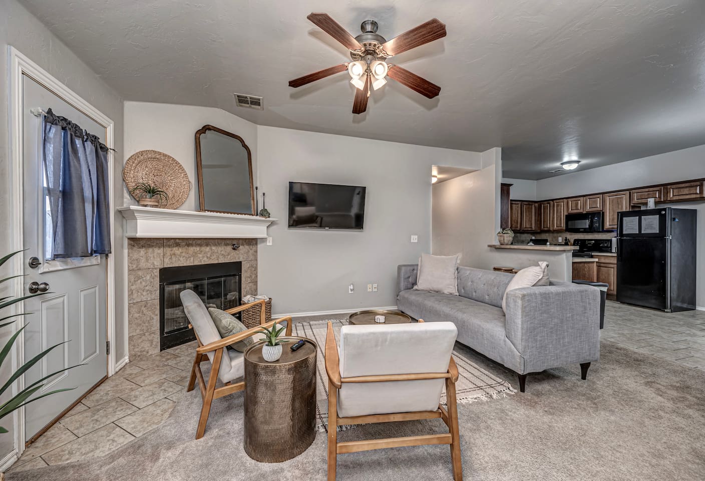 Spacious living area featuring comfortable seating, smart TV, and a warm fireplace.