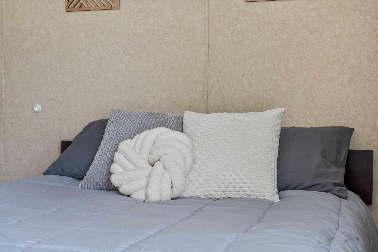 Detailed view of layered pillows and soft bedding, adding a warm and welcoming touch to the room.