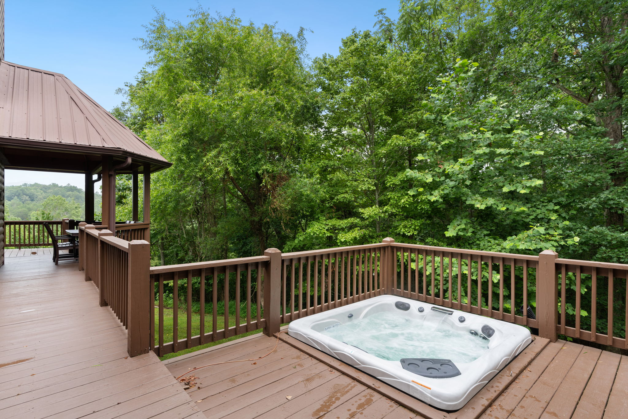 View of hot tub and outdoor covered dining area.