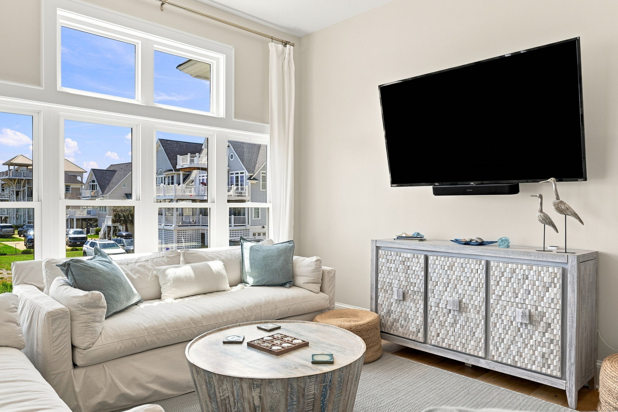 Cozy up in the inviting TV area where comfortable seating, coastal charm, and ocean views create the perfect place to relax after a beach-filled day.