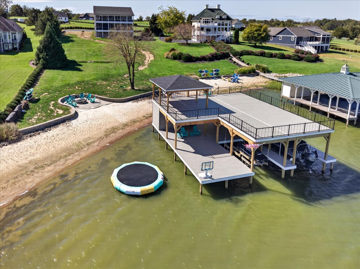 Boathouse, sandy beach, waterfront firepit, and water trampoline make the shoreline a destination of its own.