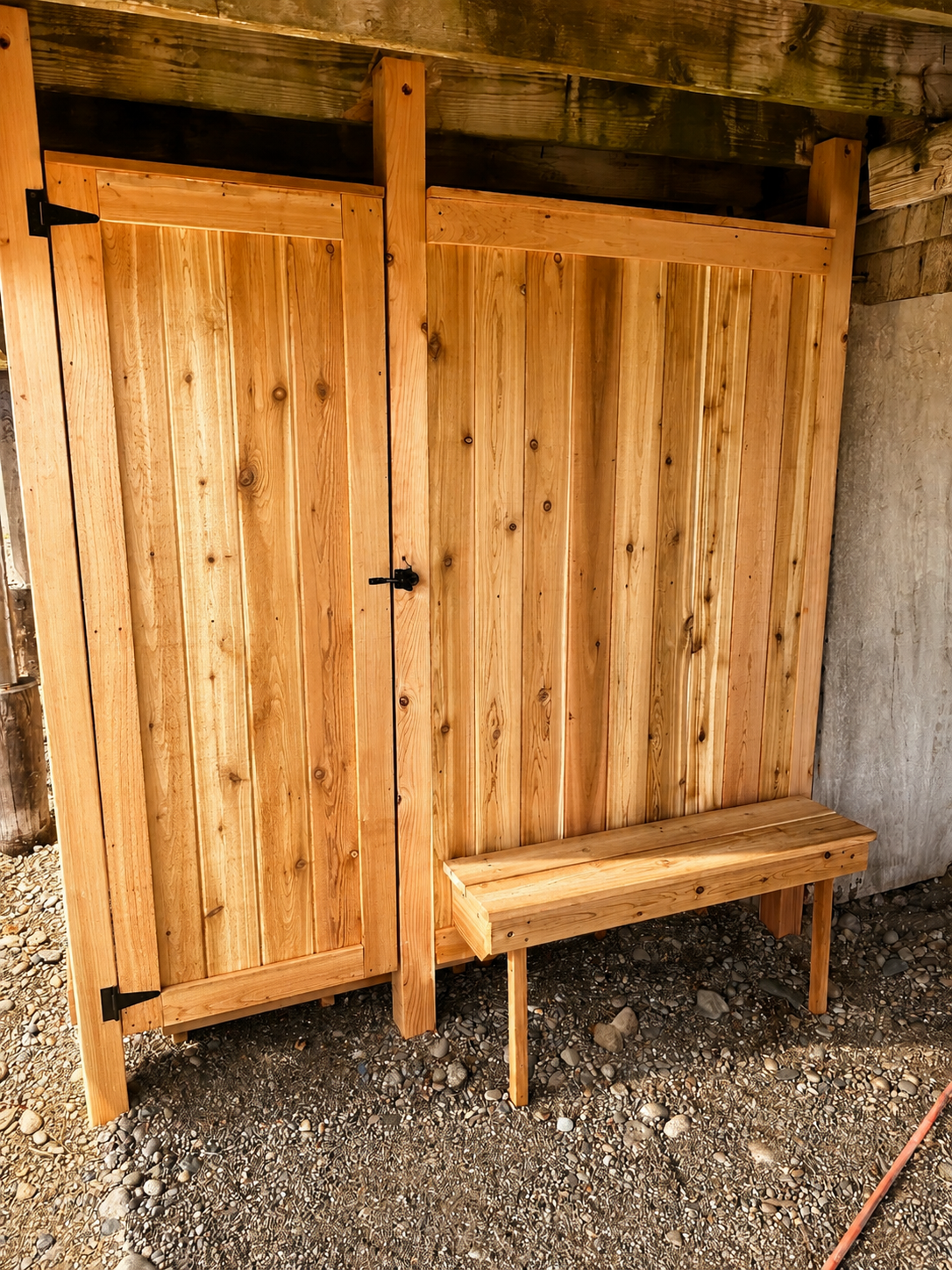 Outdoor shower with a convenient bench provides an easy spot to rinse off and refresh after the beach.
