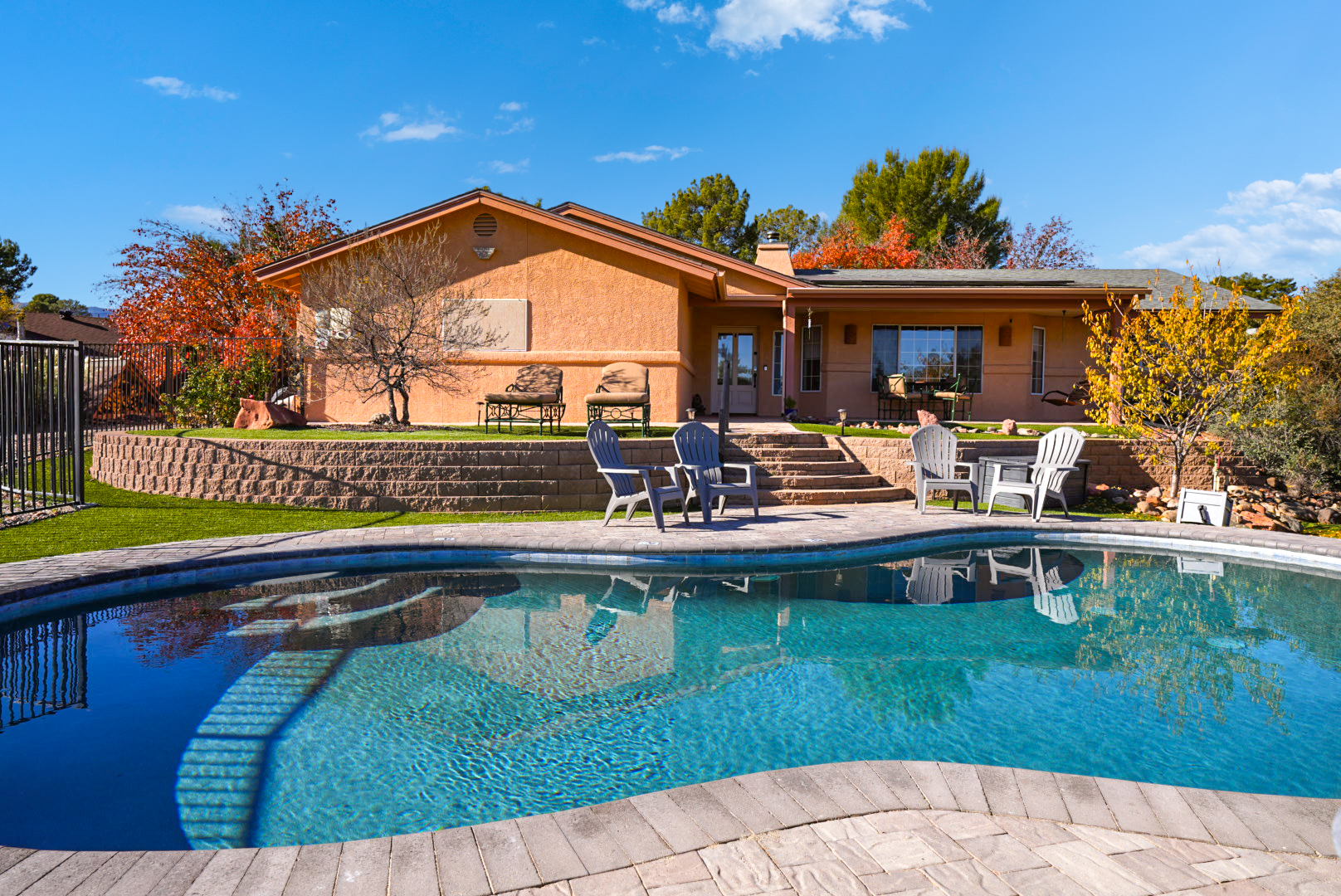 Resort-style backyard featuring a sparkling pool, multiple seating areas, and beautiful views of the home.