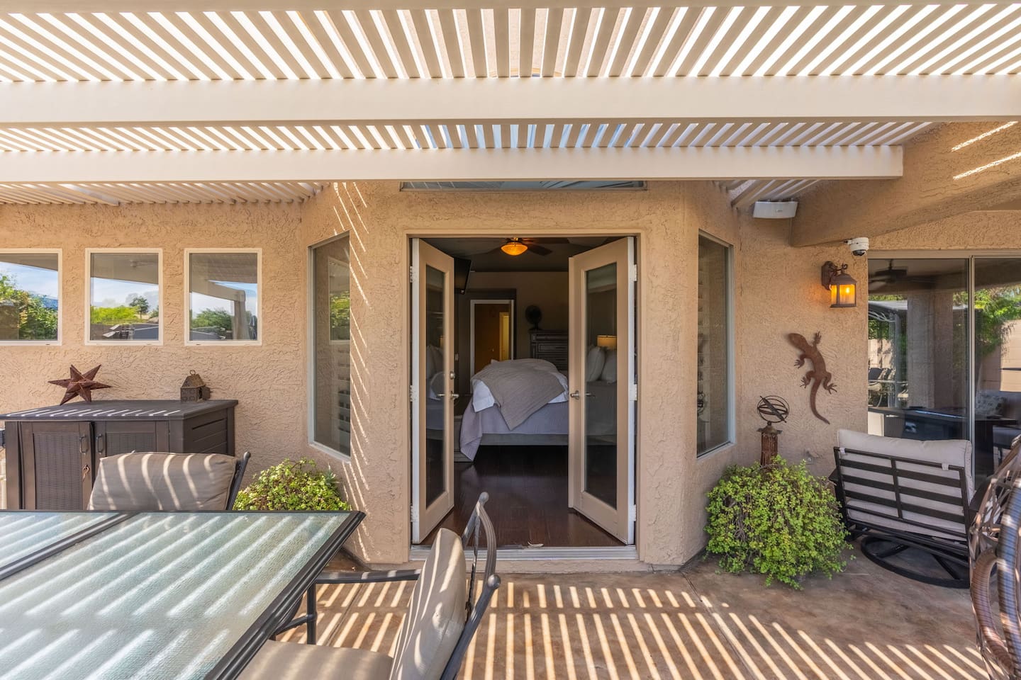 The French doors from the primary bedroom open directly onto the patio — roll out of bed, step outside, and start your morning with fresh air and lake views before the day even begins.
