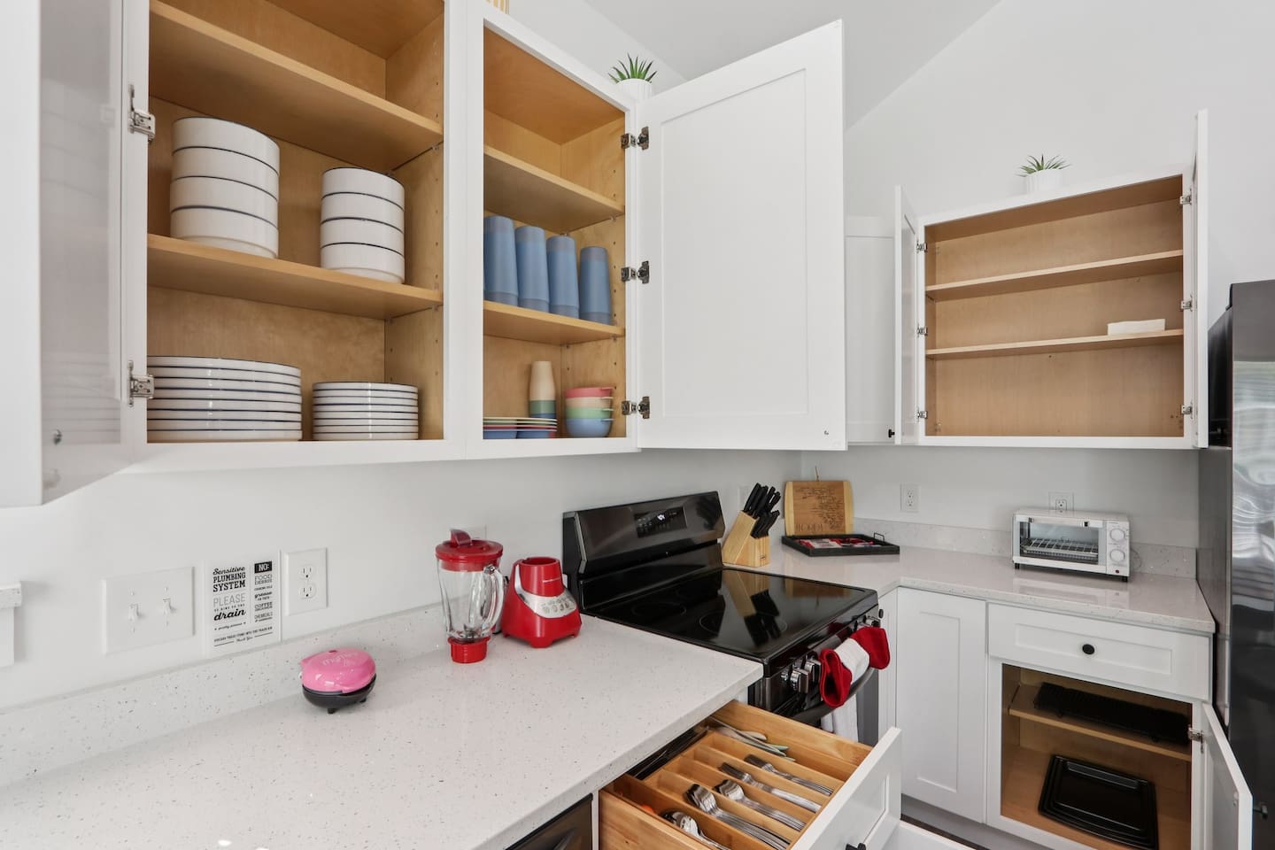 Coffee mugs with Keurig coffee maker (pods included), hot water heater, mini waffle maker, blender, stove, oven, dishwasher, fridge, filtered water, knives, cutting board, pots/pans, baking sheets, utensils.  