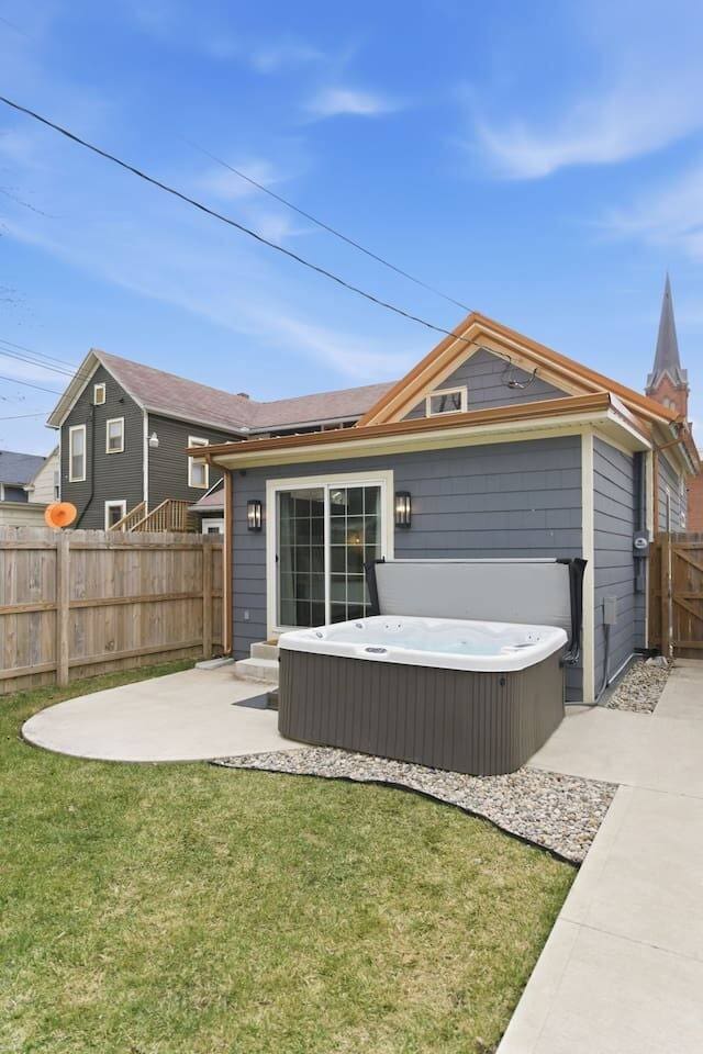 Private outdoor space with hot tub and fenced yard for added comfort and privacy