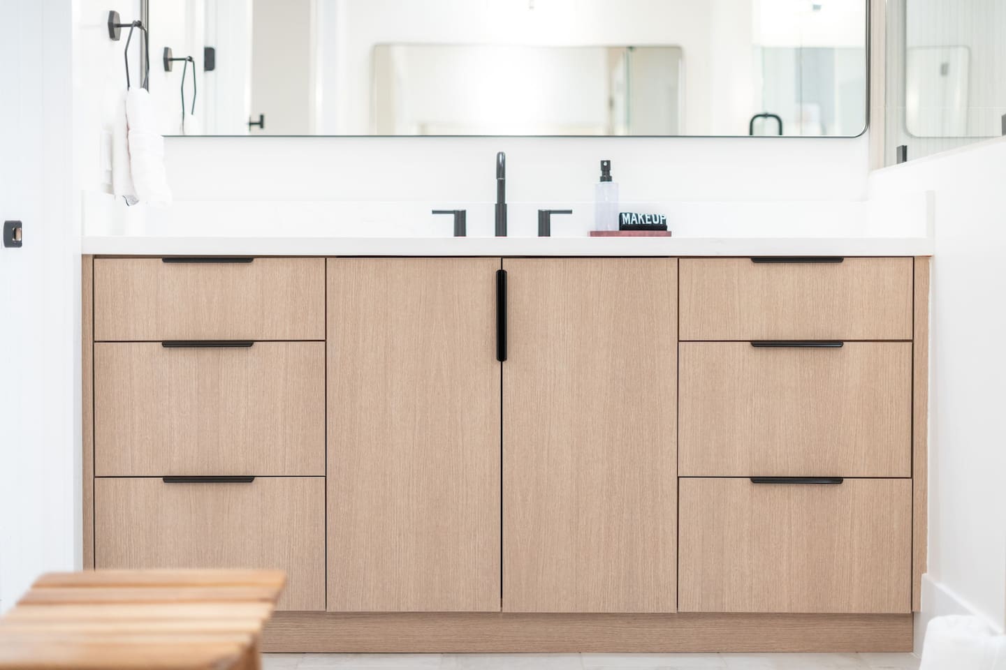 Double vanity with natural wood cabinetry and ample storage.