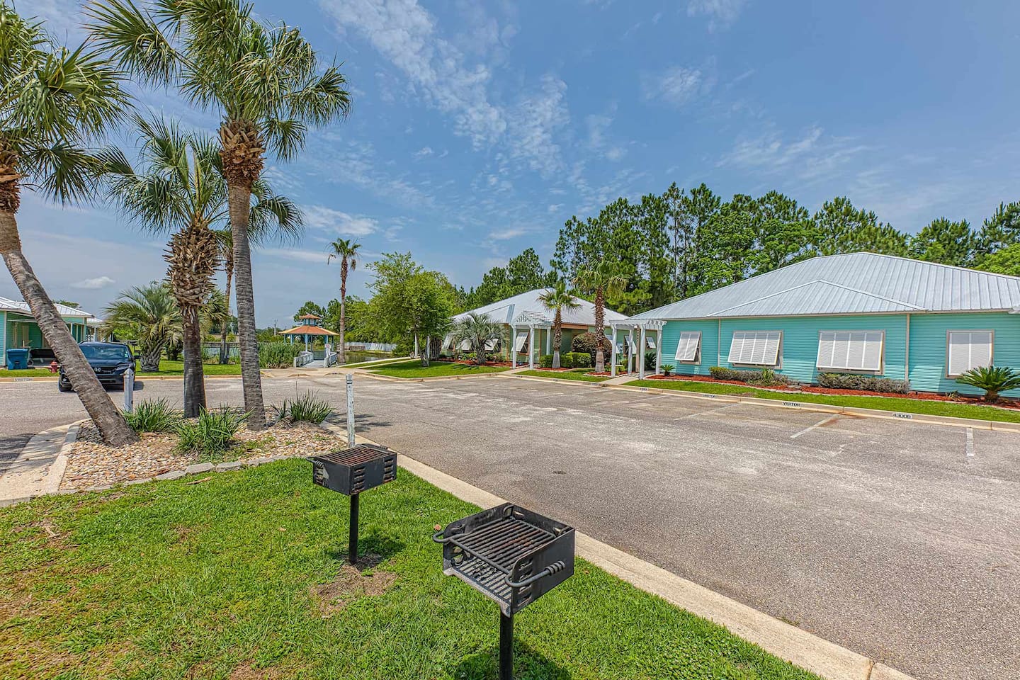 Exterior Oasis: Enjoy sunny days under palm trees with BBQ grills and vibrant surroundings!