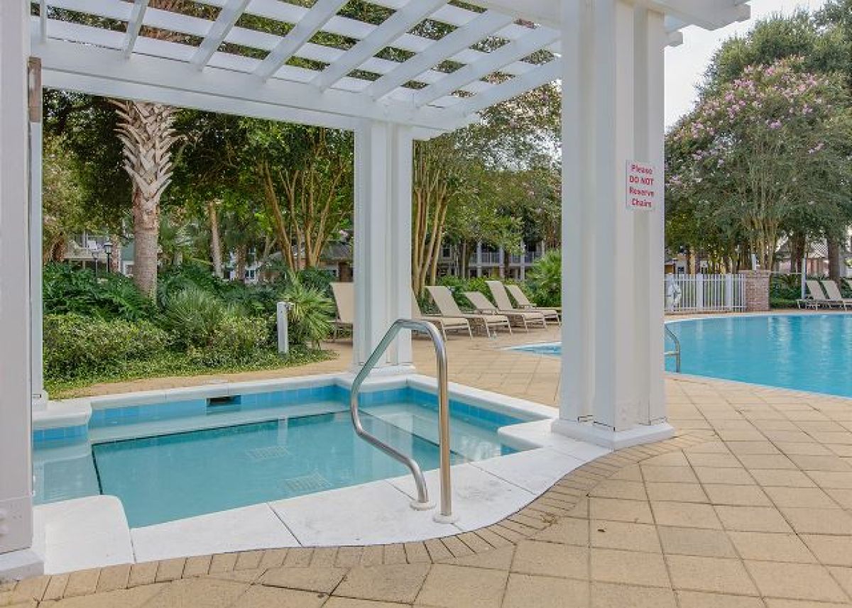 Hot tub under a white pergola beside the Pilot House pool and lounge chairs