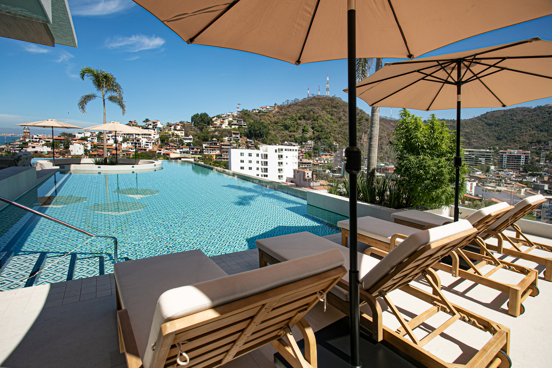Dive into the rooftop infinity pool—an unmatched spot to relax above the Romantic Zone with sweeping mountain and city views.