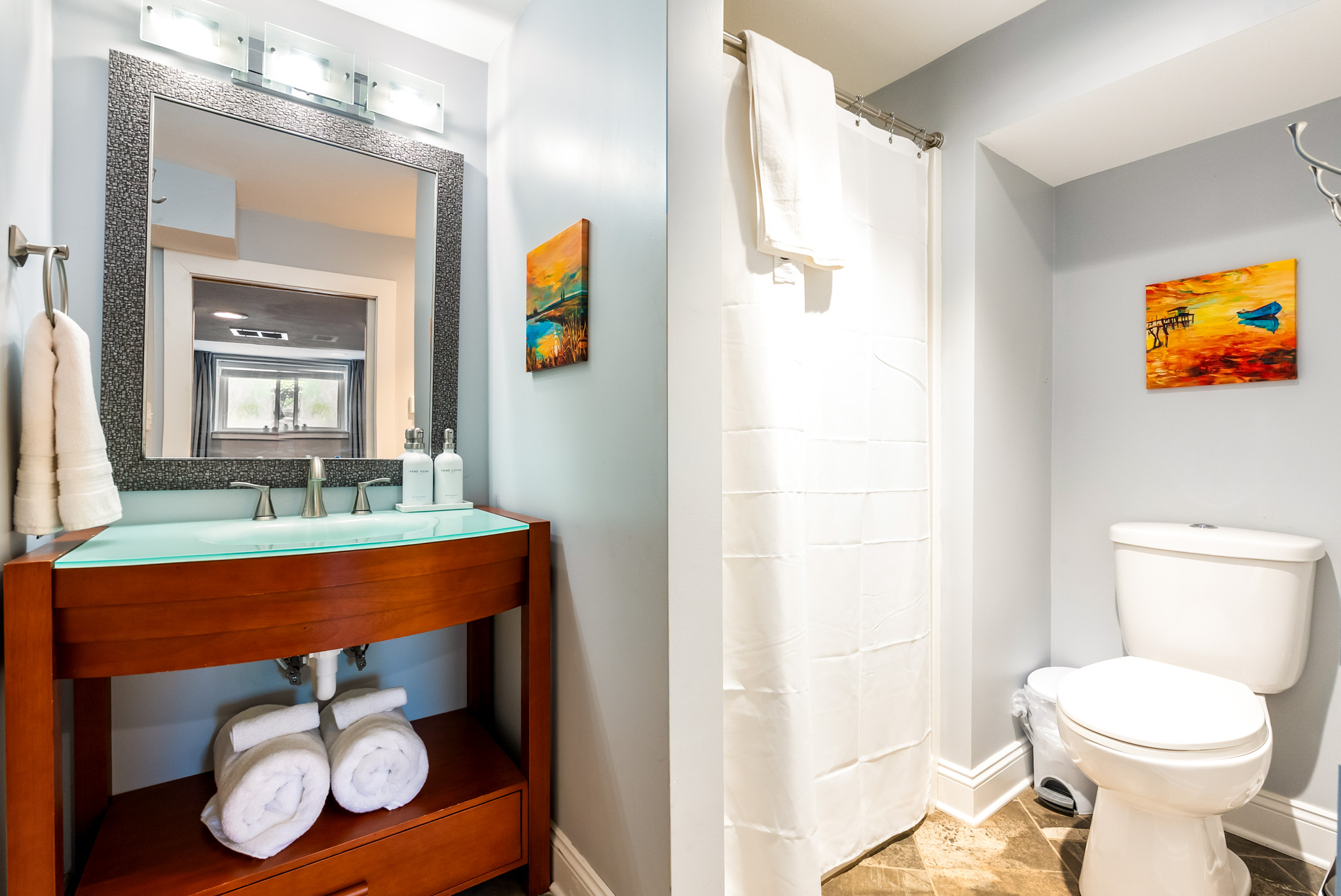 Clean and refreshed. The suite's bathroom layout includes a modern single vanity with ample counter space, bright lighting, and a walk-in shower.