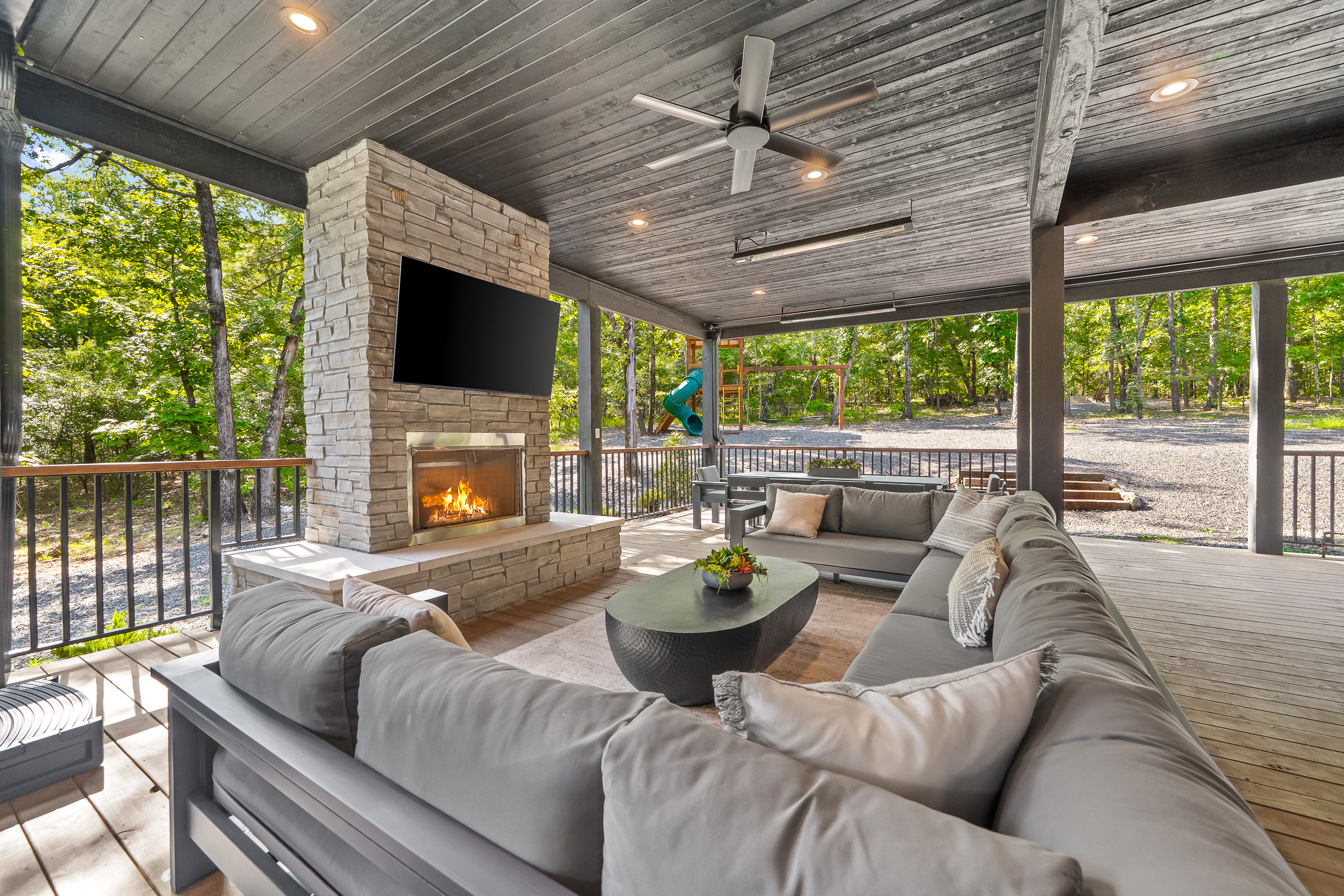 Large covered patio includes a gas fireplace, hot tub, smart TV, large spacious sectional, and outdoor dining area. Includes infrared heaters included as an extra bonus for all-weather enjoyment!