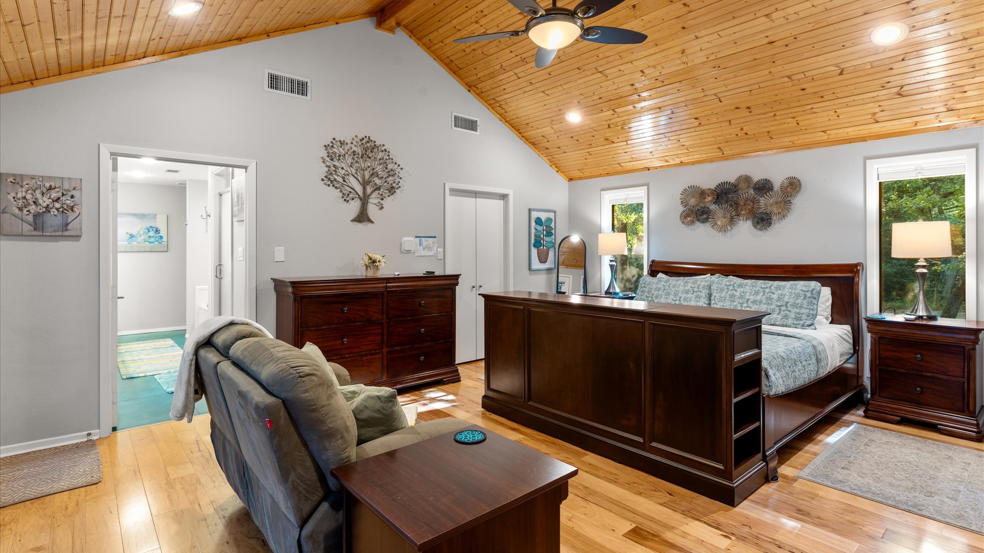 King 1 Bedroom has warm pine floors and ceiling, creating a cozy feel. It includes a door to the backyard, a full-size closet, and all the comforts for a relaxing stay.