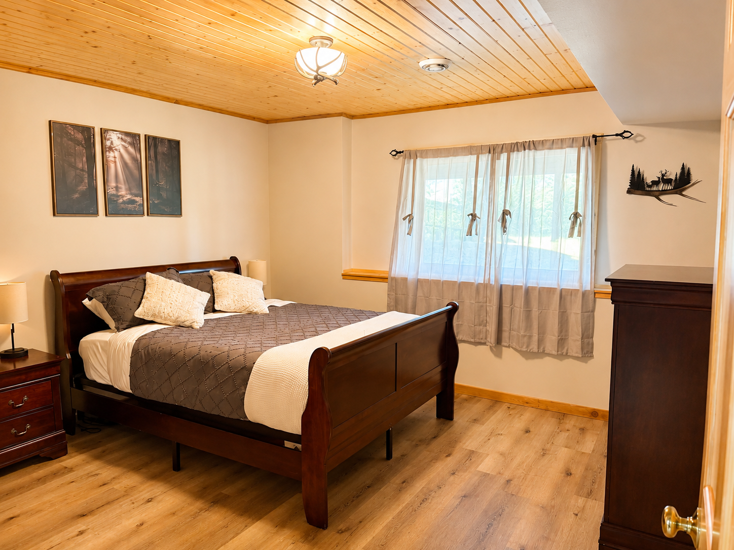 Basement bedroom with warm wood floors and a comfortable bed provides a quiet place to recharge.
