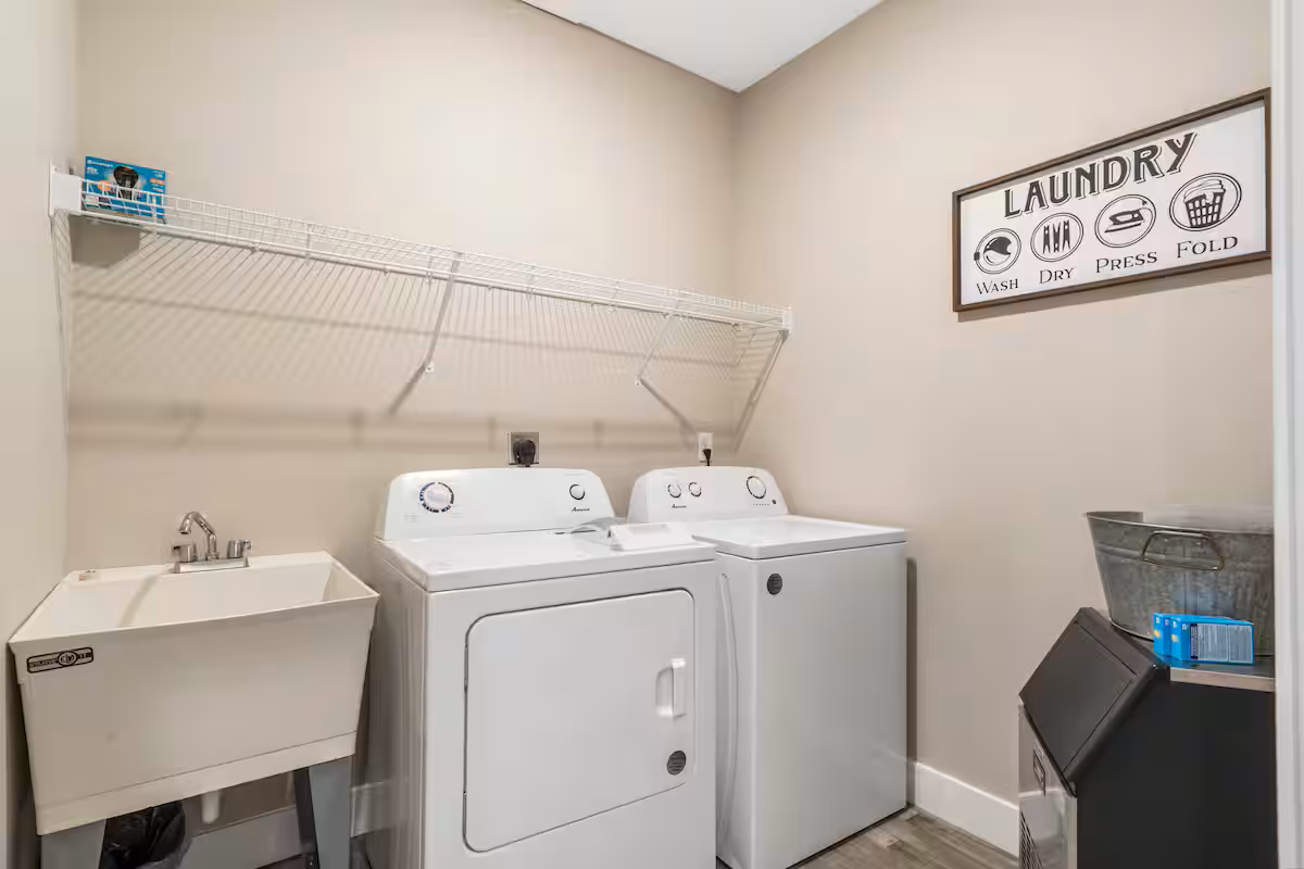 Upper Laundry Room with washer, dryer, laundry sink, ironing board and iron. It also has an ice machine for filling coolers when going to the lake or community pools.