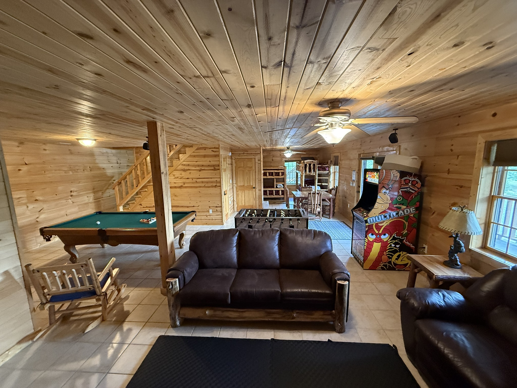 Game room from back where see sofas and bunk beds in back along with Pool table, Foosball, and Arcade Games