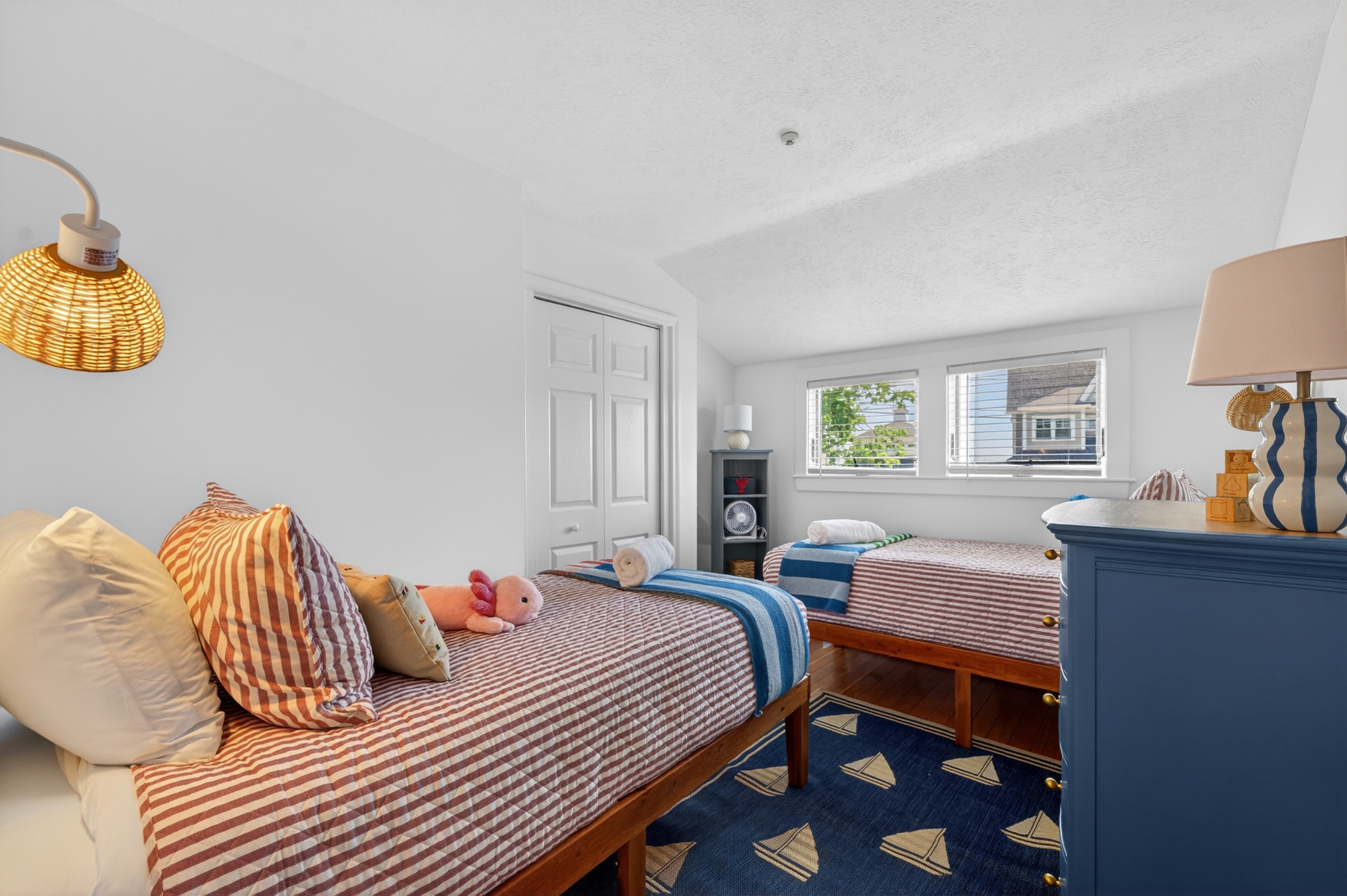 Cheerful twin bedroom with two beds and cozy coastal touches, ideal for kids or extra guests.