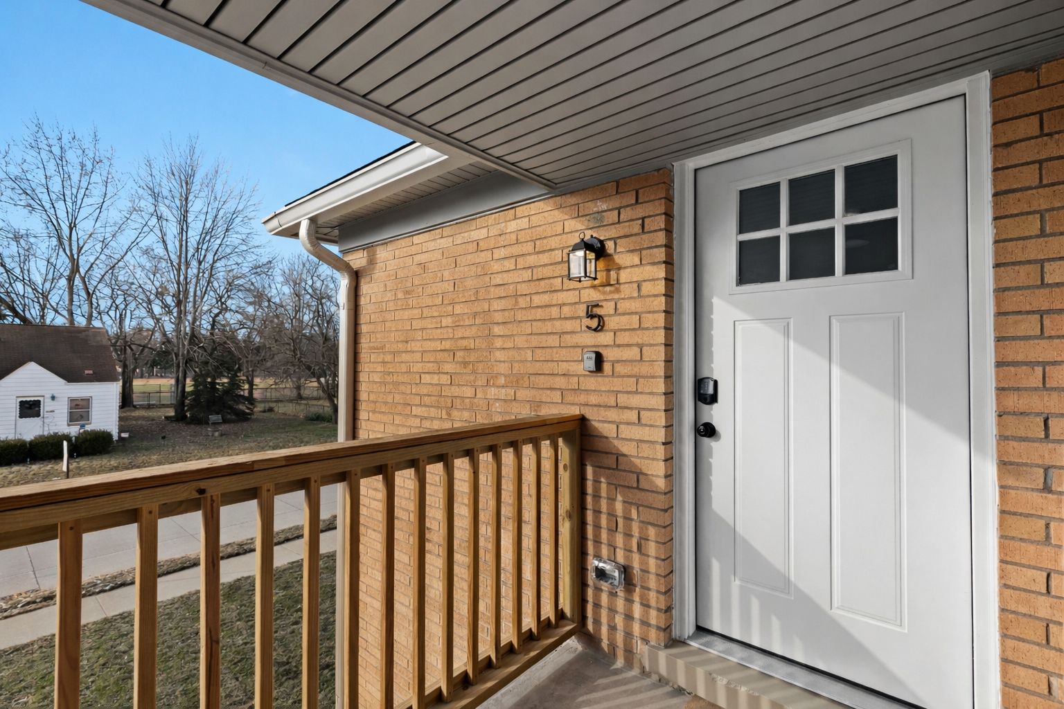 Welcoming private entrance with covered walkway and exterior lighting—easy access, added privacy, and a great first impression.