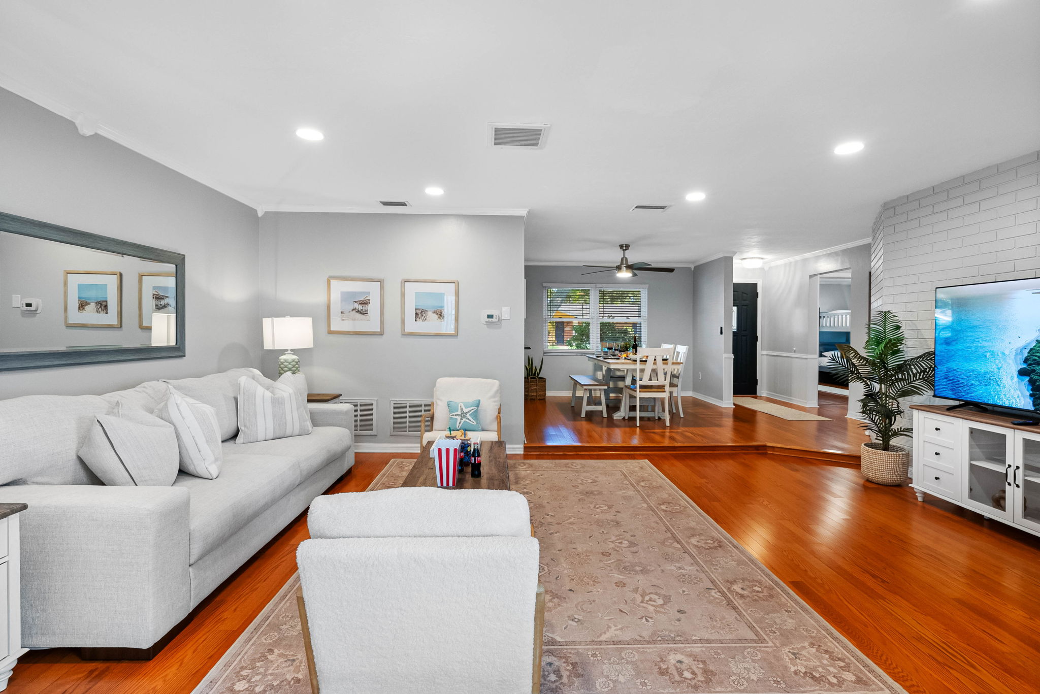 This light-filled living room offers plush seating, a large smart TV, and coastal-chic decor that sets the tone for a relaxing stay.