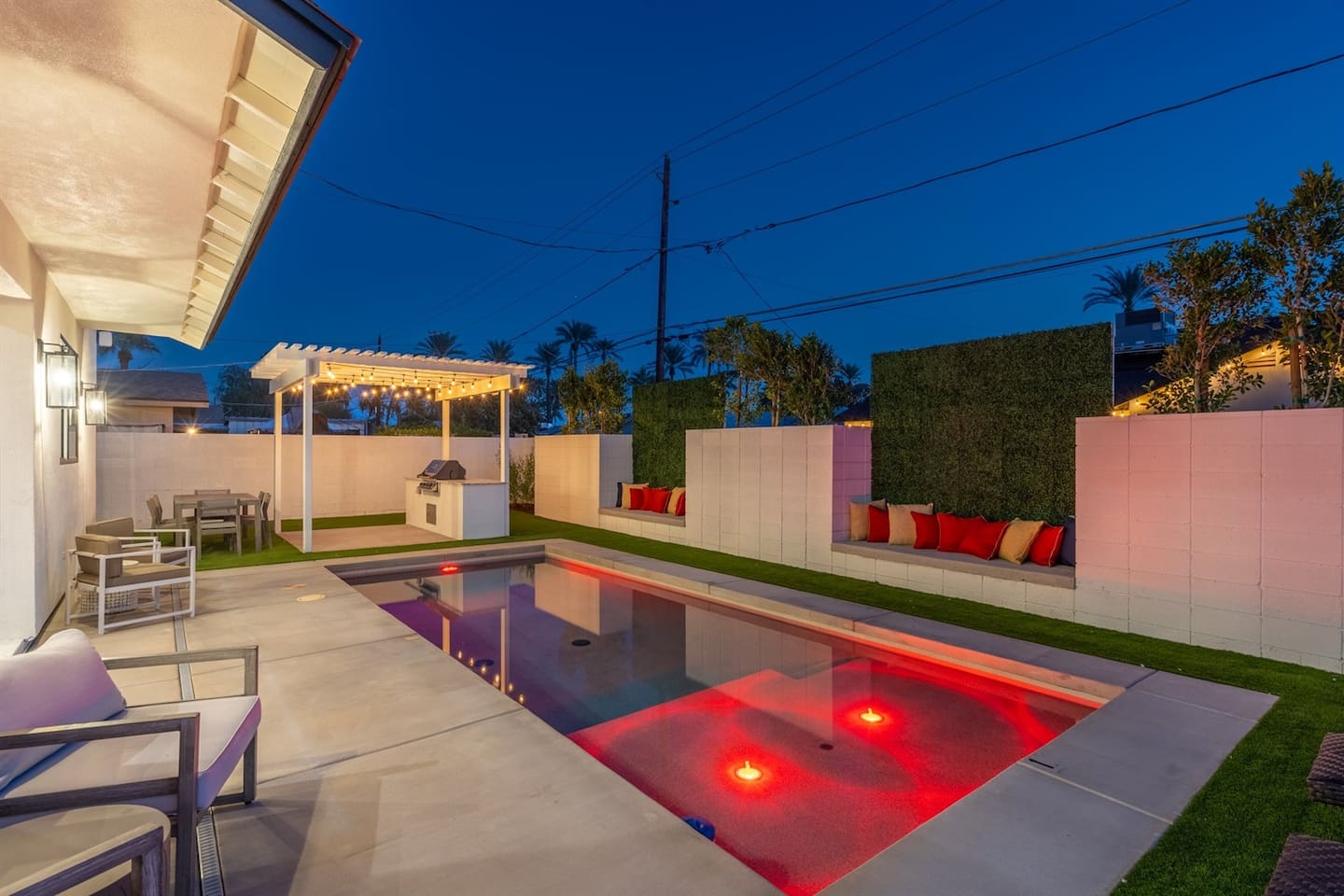 Experience the magic of the night by the pool, featuring comfortable seating, a beautifully lit pergola with a grill area, and dining tables for evening meals under the stars.