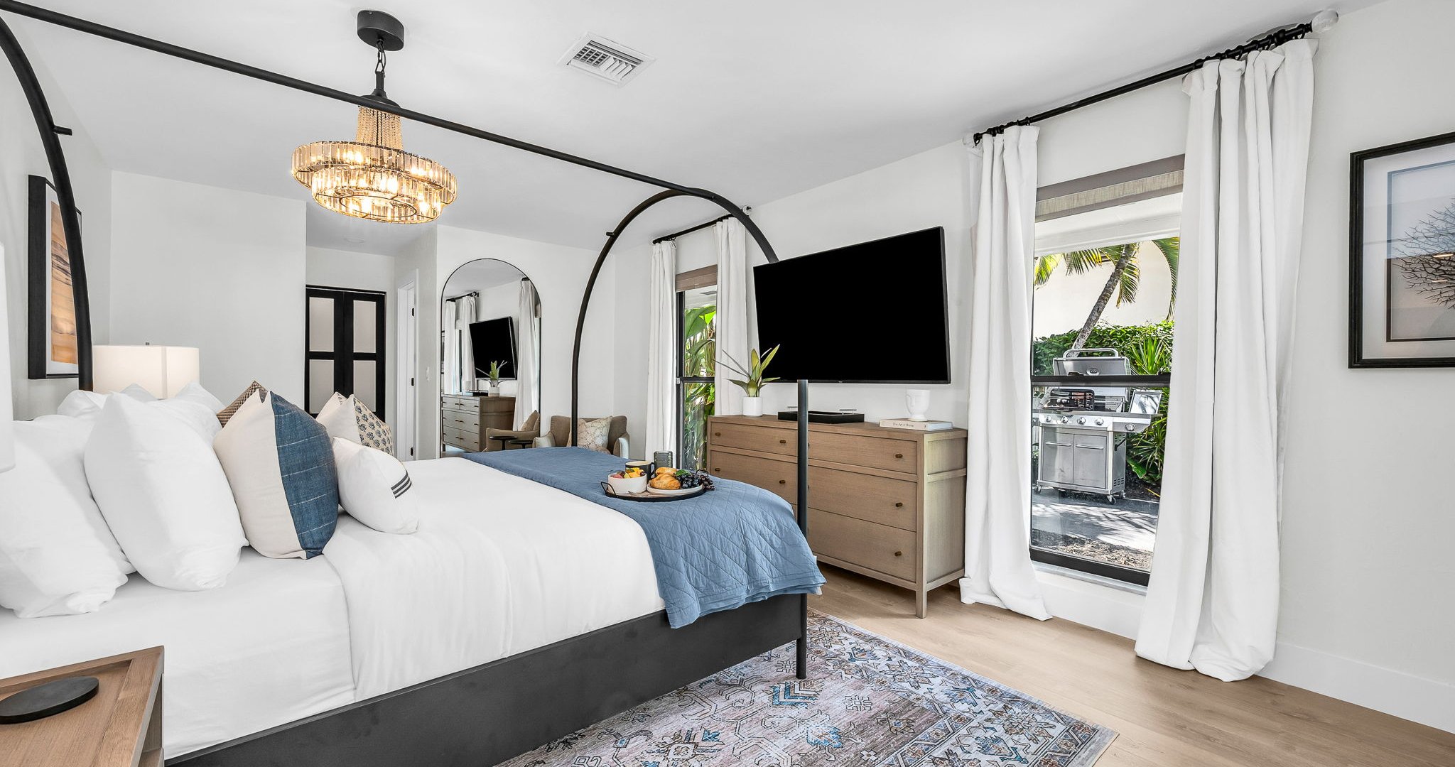 This second primary suite offers a plush king bed, private ensuite bathroom, and walk-in closet for added comfort. Enjoy poolside views and direct access to the outdoor living area, making it the perfect blend of luxury and convenience.