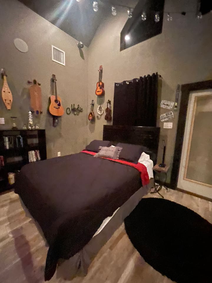 Queen bed with TV and air hockey table.
