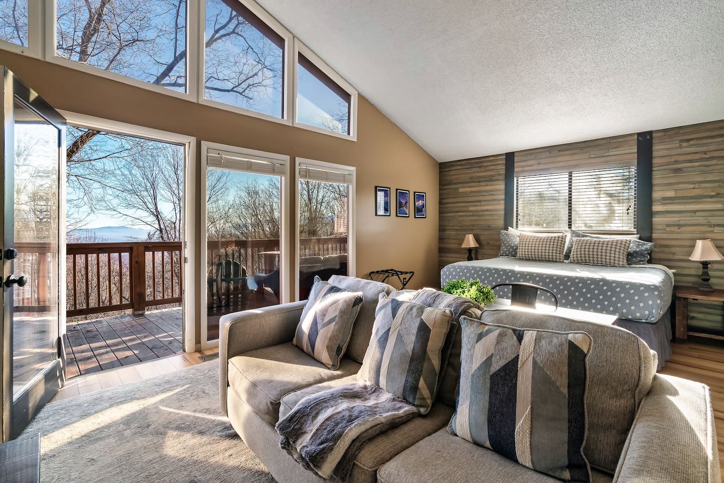 Beautiful master bedroom suite with its own living area, stone fireplace, vaulted ceiling, and private deck with a seasonal view. Plus desk.