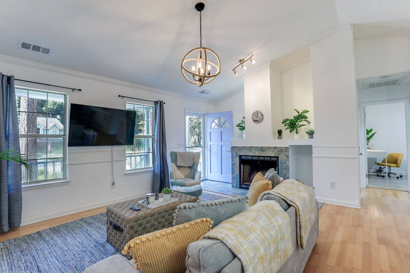 The living room is bright and airy, with large open windows that let in plenty of natural light, high ceilings that create a spacious feel, and a smart TV for your entertainment needs.