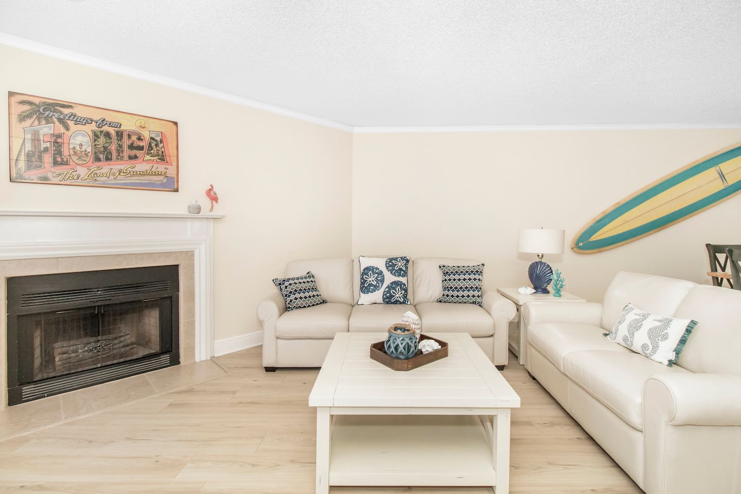 Living room with fireplace, open to the dining and kitchen area with pool and gulf views. 