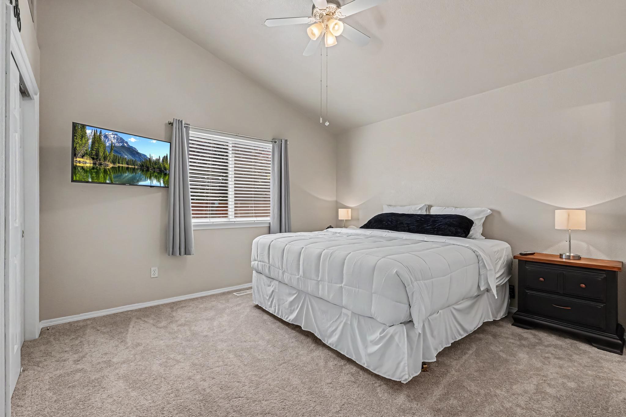 The spacious primary bedroom features a comfortable king-size bed, ample space to relax and unwind, and a smart TV for your convenience. It’s the perfect retreat after a day of exploring or spending time with family.