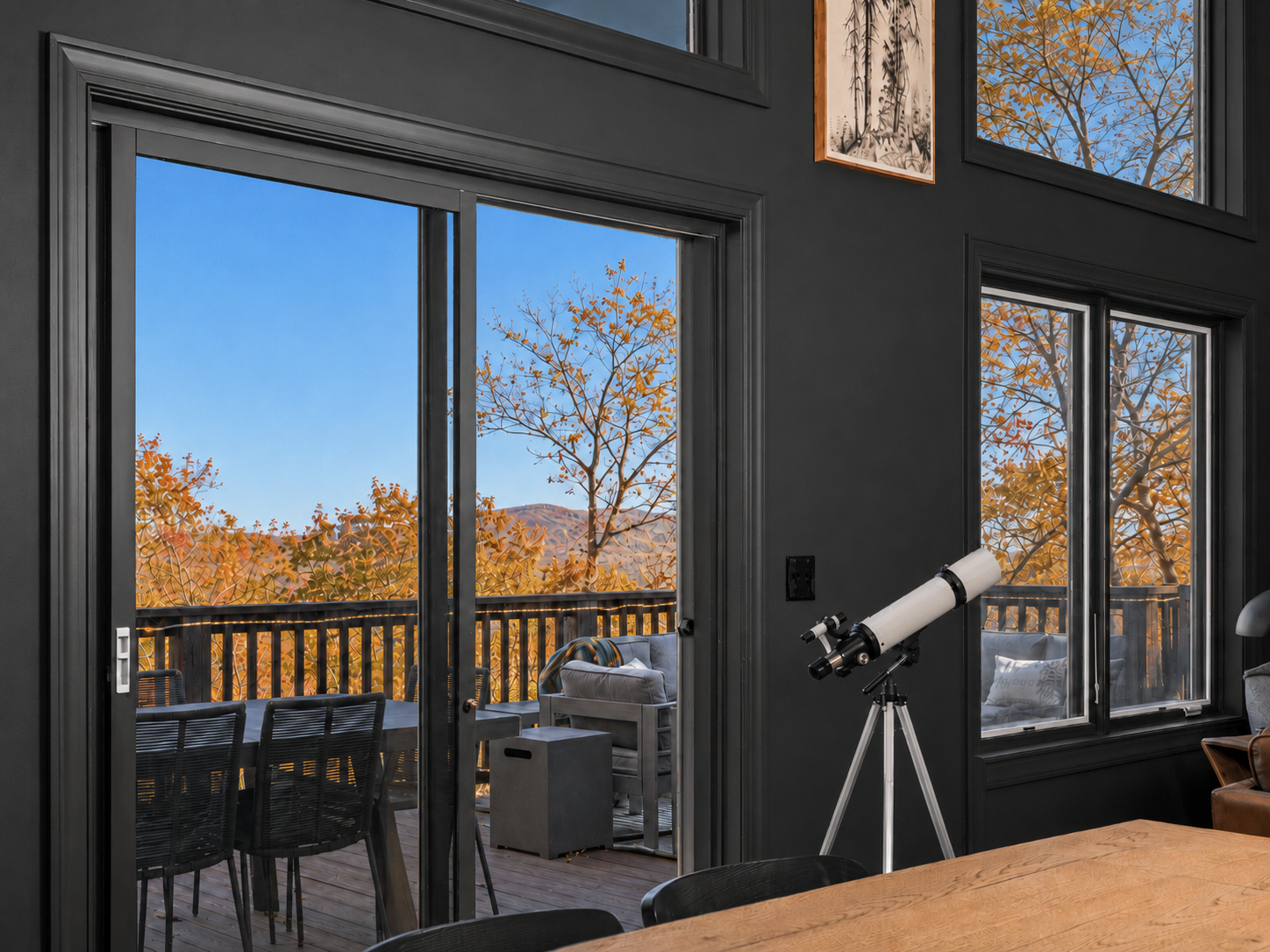 Dining room with sweeping treetop and mountain views, a telescope for taking it all in, and direct access to the deck. In fall, the surrounding canopy glows with gold, orange and red.