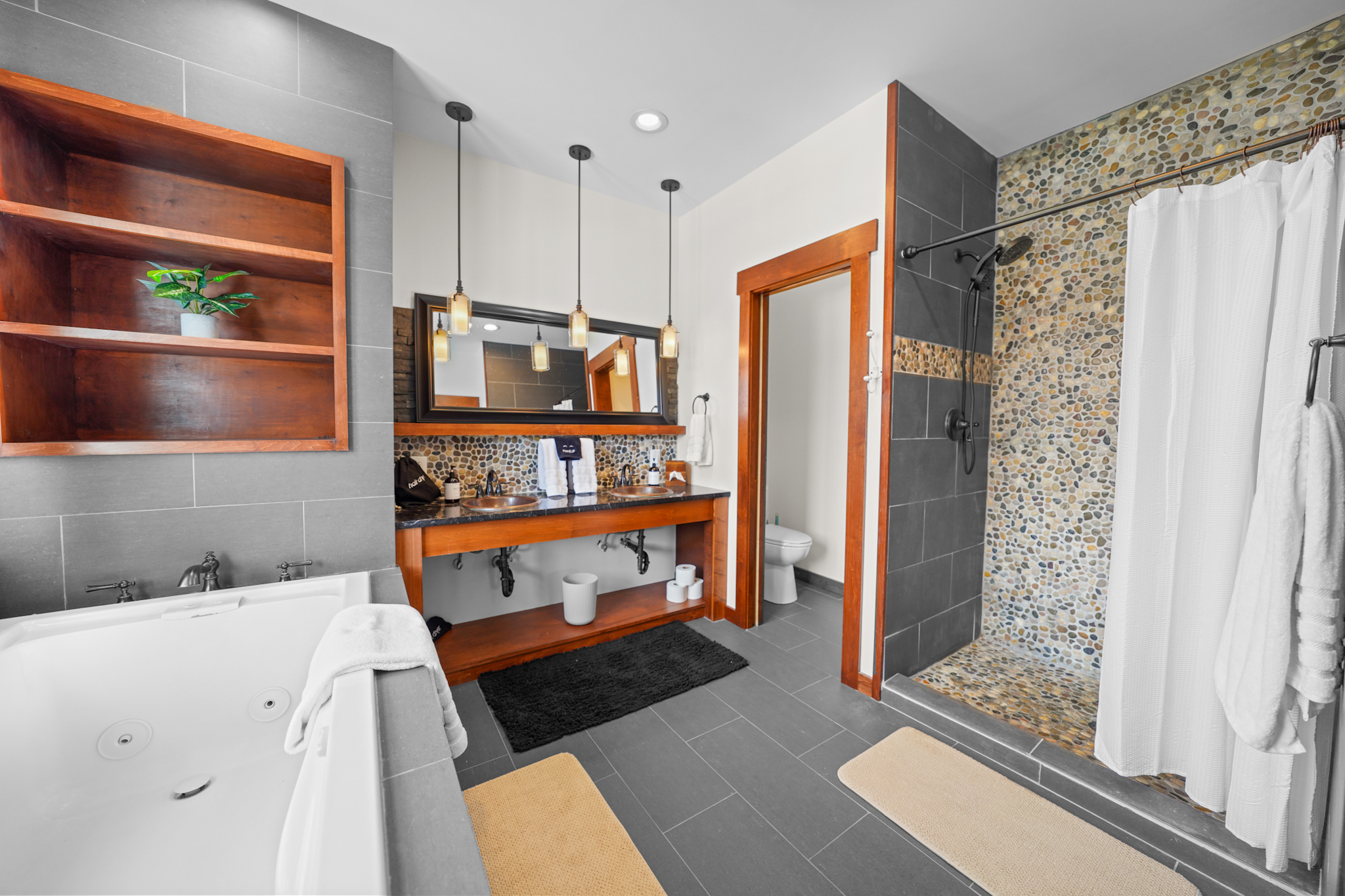 Spa-like primary bath featuring a jacuzzi soaking tub, walk-in shower, and dual vanities.