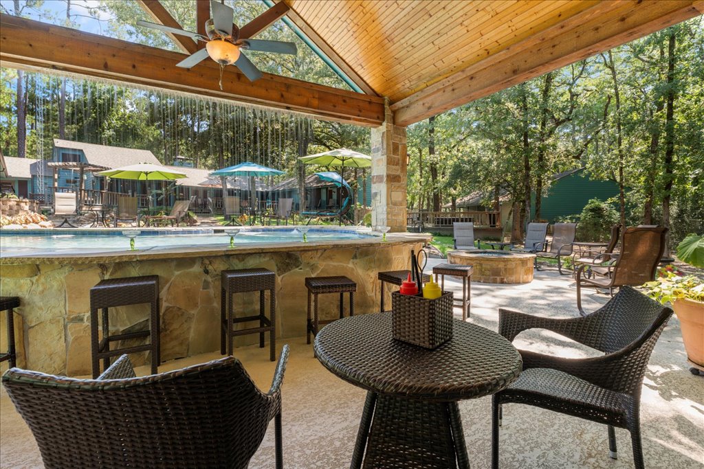 The outdoor kitchen features both a bar and a small dining table, giving you the perfect setup to enjoy a delicious meal while relaxing poolside.