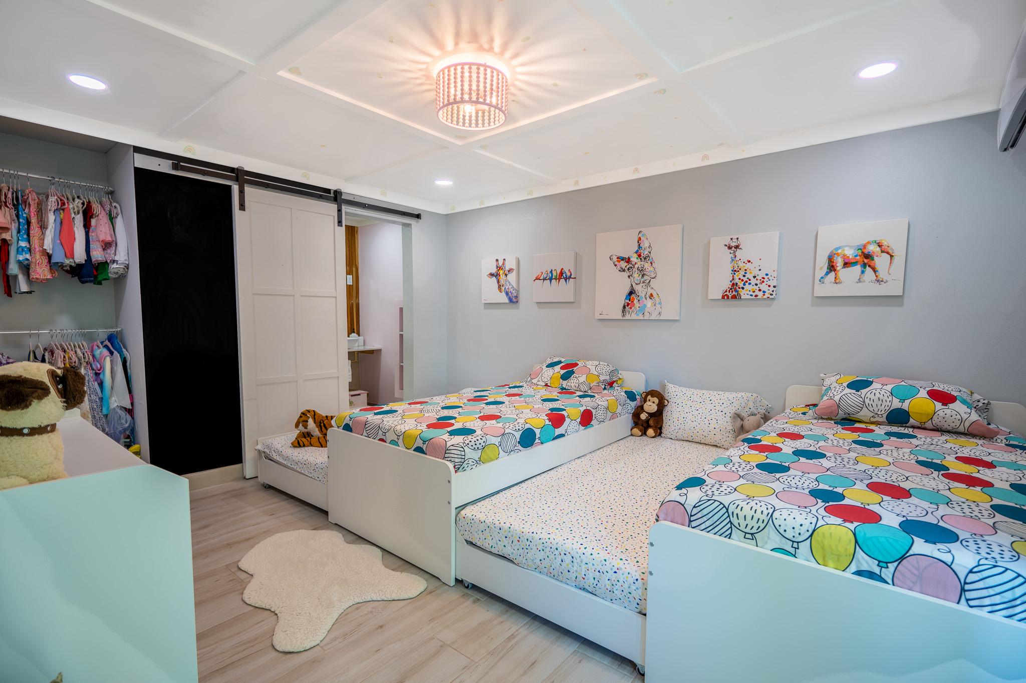 This is the view of the kids room, featuring 4 twin beds, bright colors, and blackout curtains for naptime in Dorado, Puerto Rico.