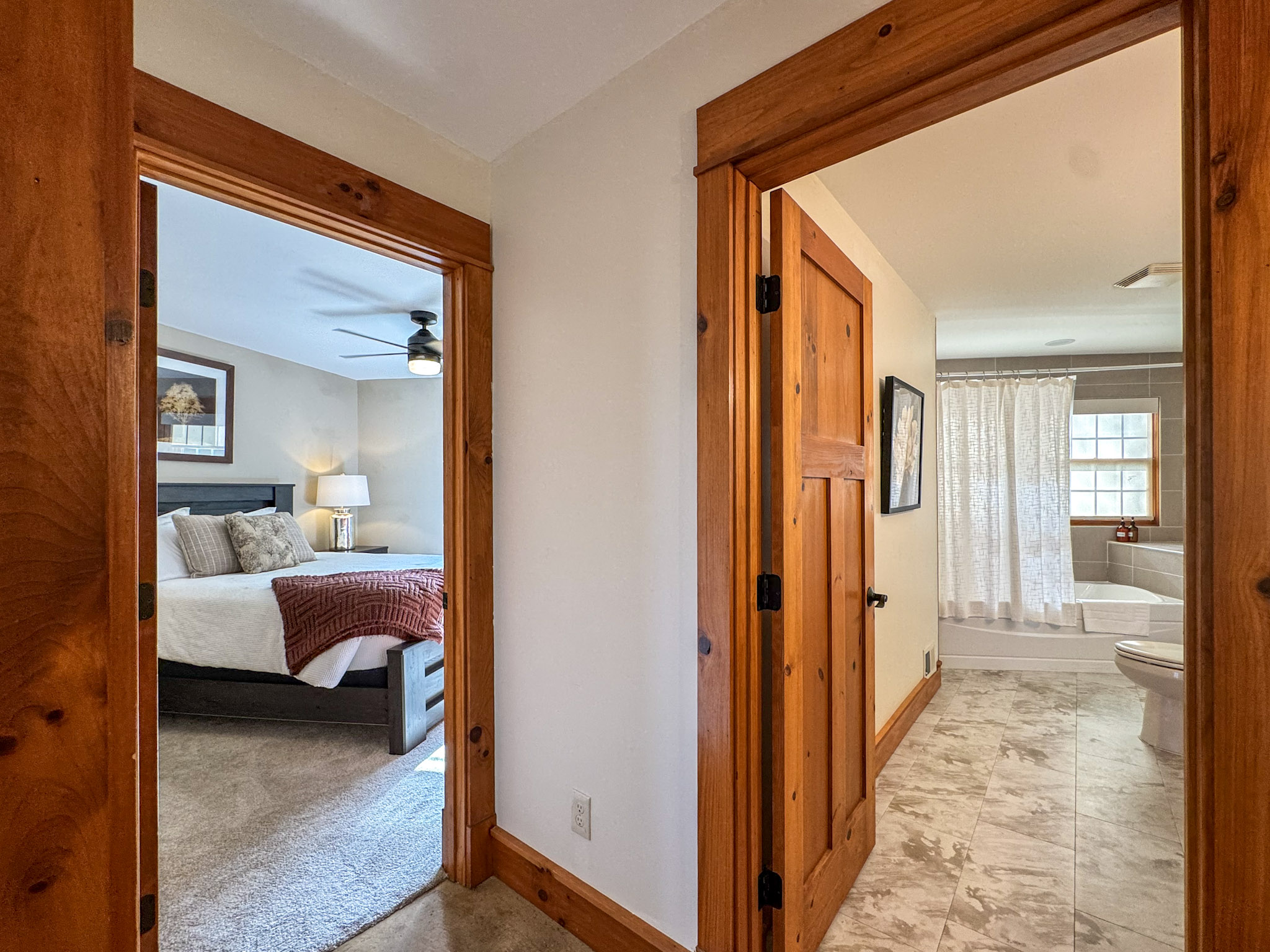 Hallway view of a bedroom and adjacent bathroom.