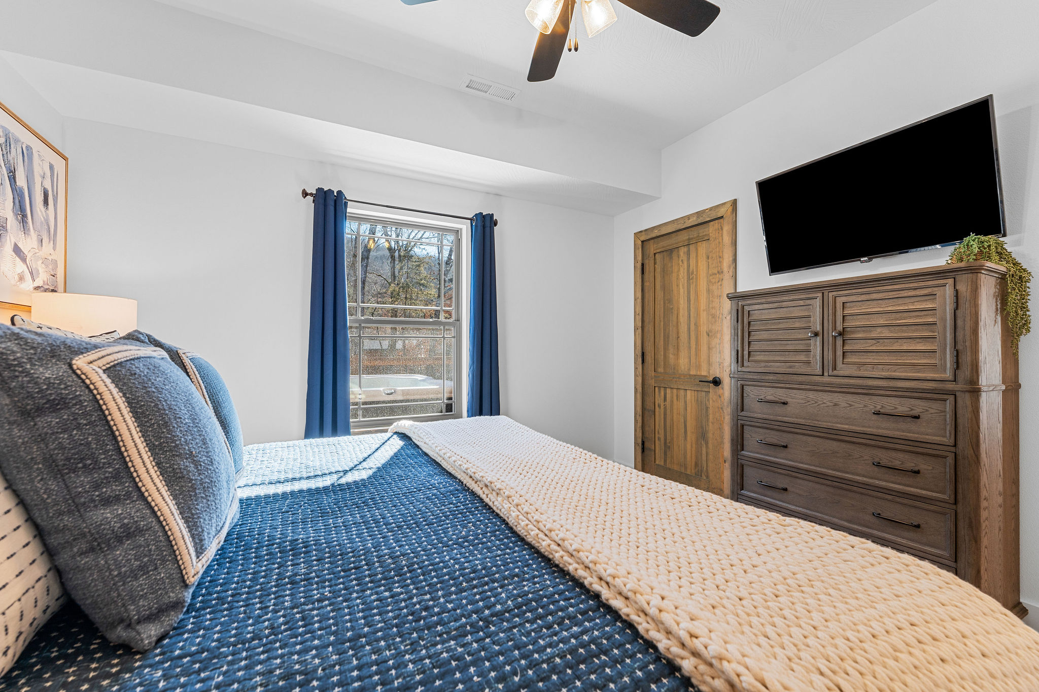 Spacious bedroom view featuring a dresser and TV for added convenience.