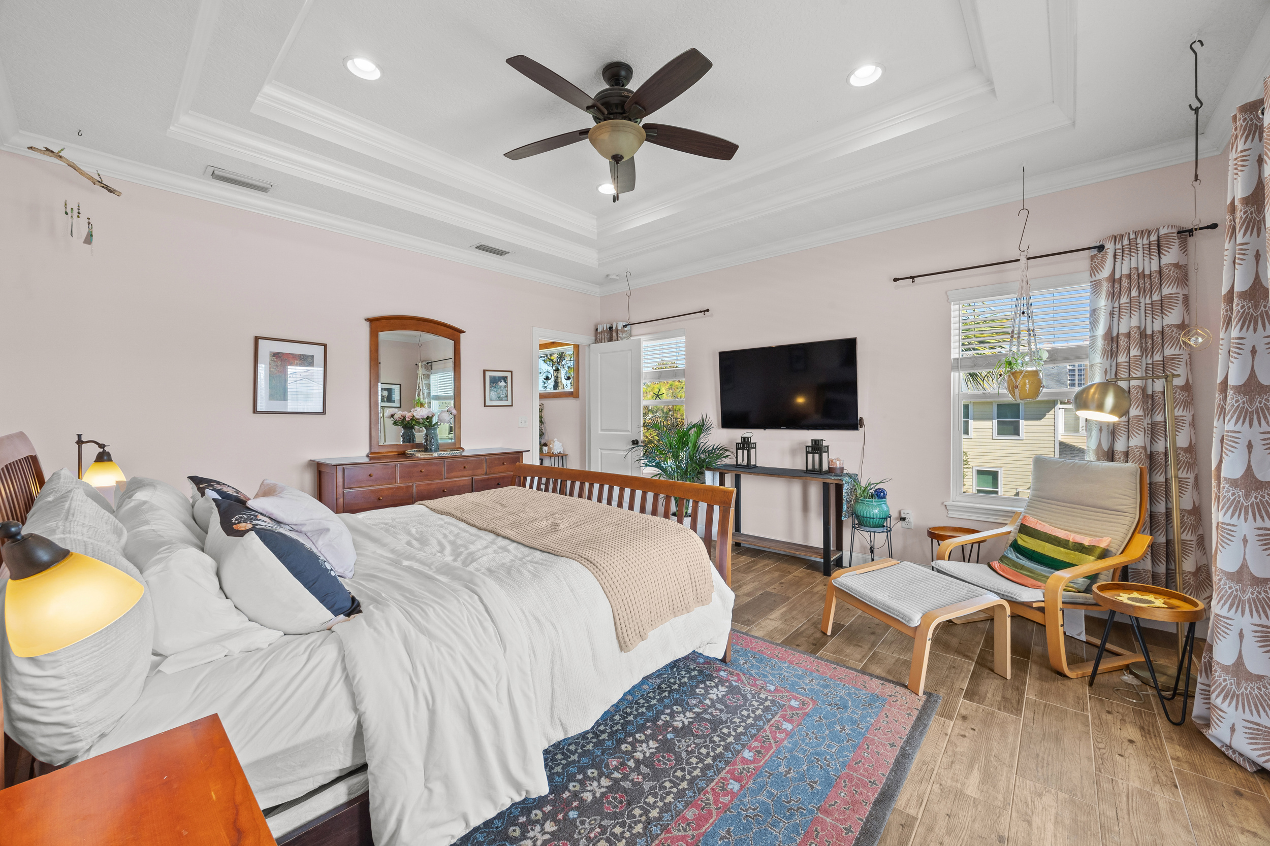 Comfortable bedroom with lounge chair, dresser, and soft lighting in Jacksonville Beach rental home.
