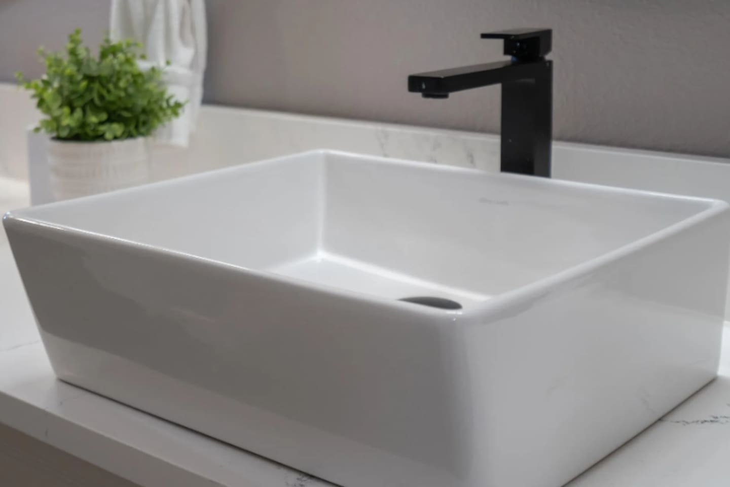 A sleek vessel sink and matte black fixtures add a modern touch to the bathroom details.

