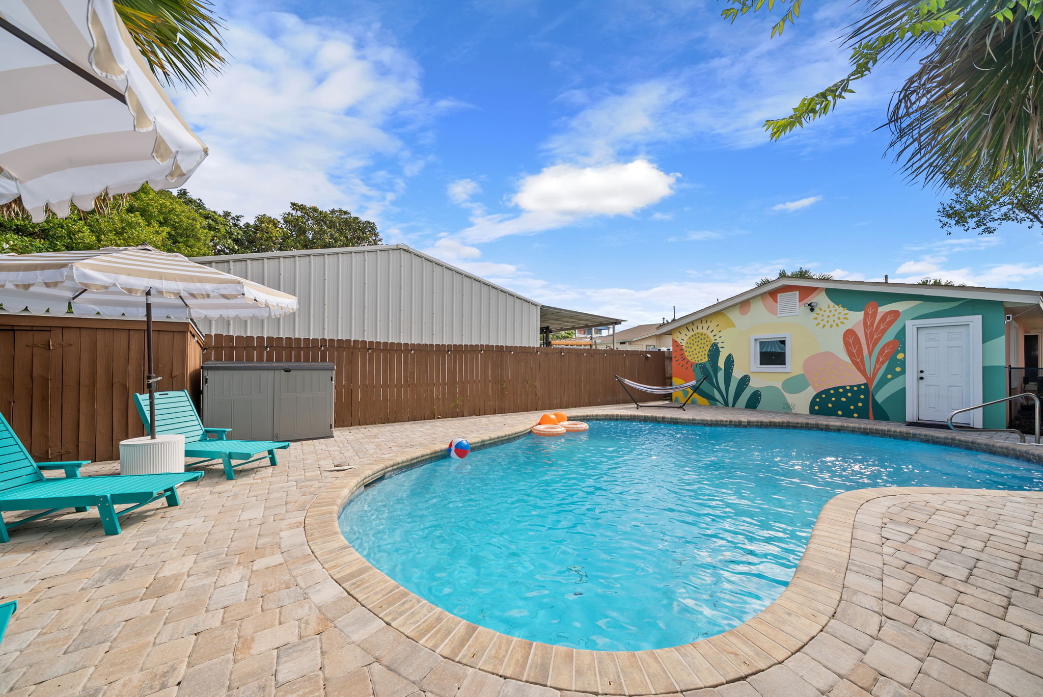 Lounge poolside with a colorful mural as your backdrop and
a pool toy at arm's reach. This is the backyard view that greets you every morning.