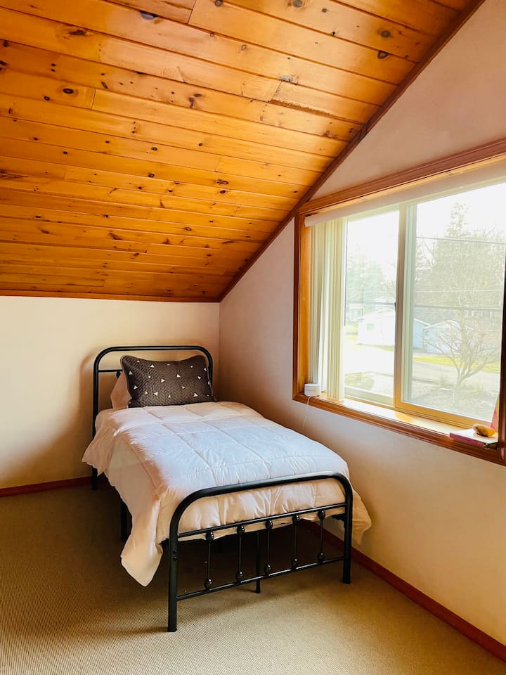 Quiet bedroom with large window and peaceful lake house atmosphere.