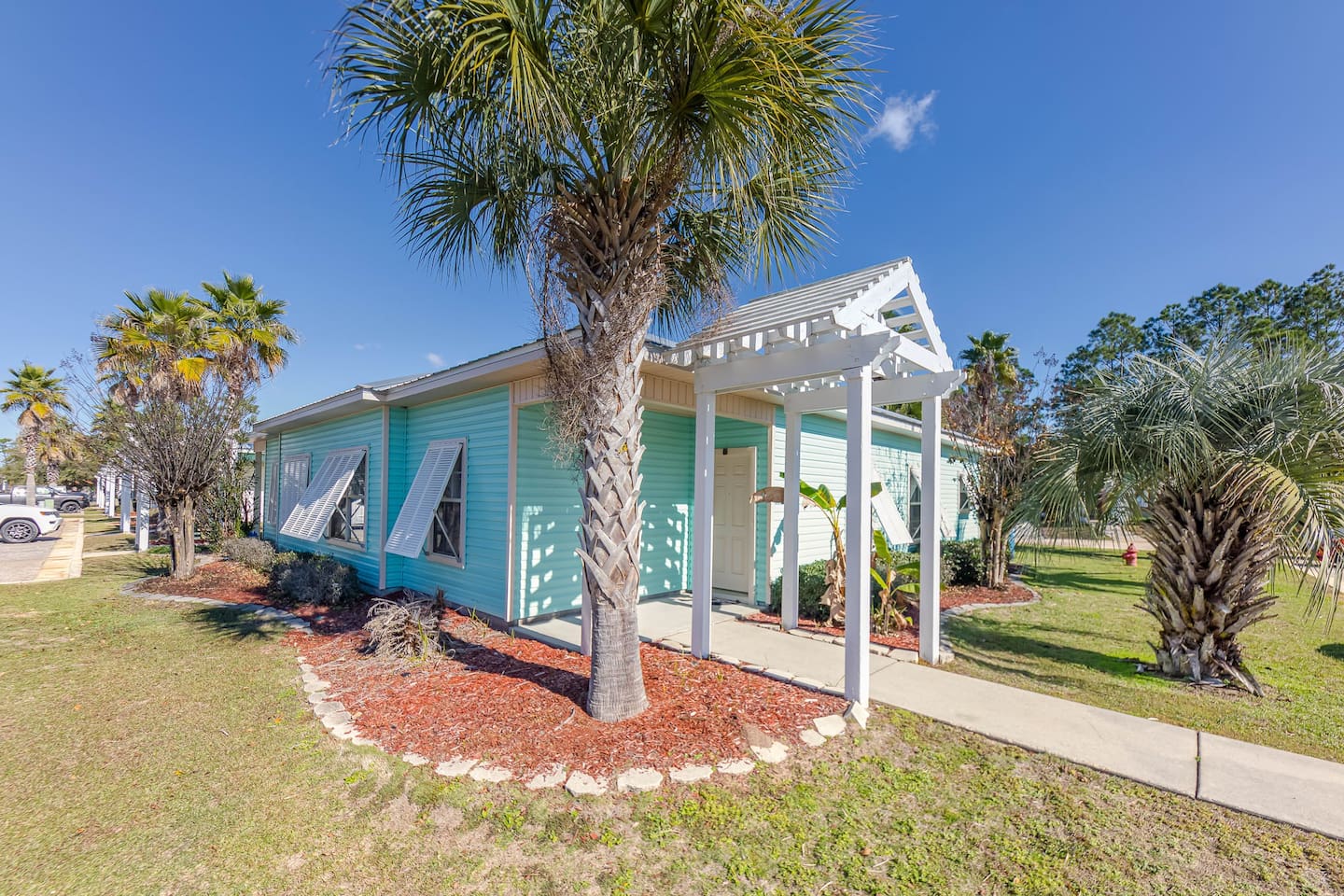 Exterior View: Vibrant beach house surrounded by swaying palms and colorful landscaping!