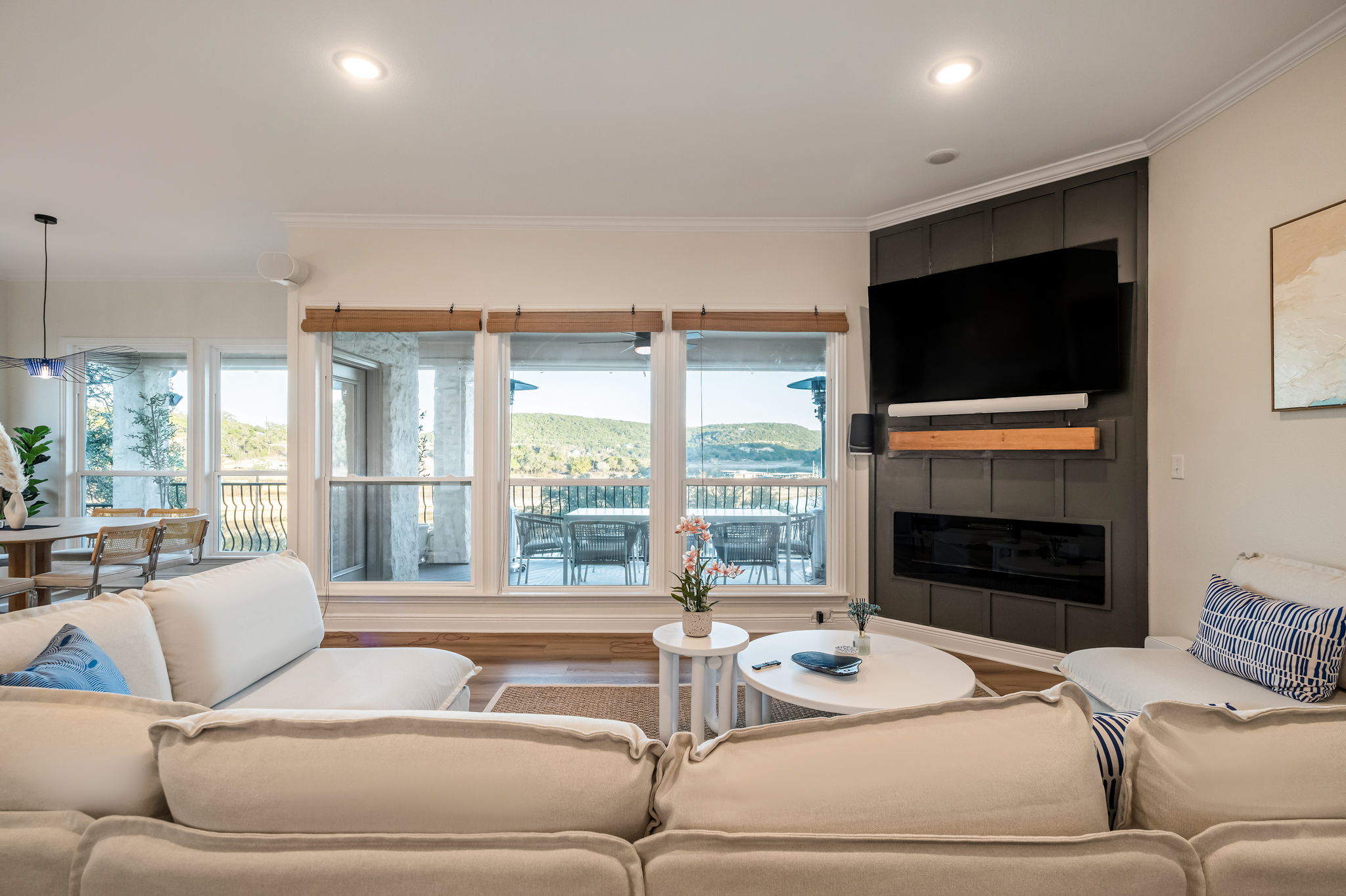 Comfortable family lounge with panoramic lake views and modern fireplace — ideal for relaxing nights in.