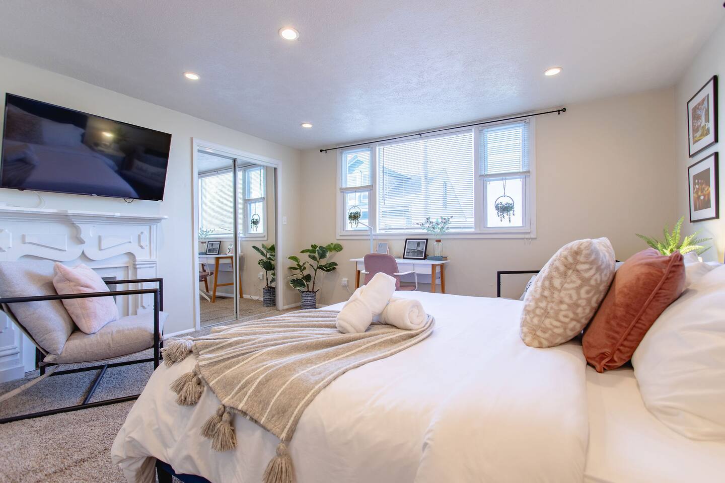 Cozy, spacious room with a queen-sized bed, TV, and a dedicated working space.