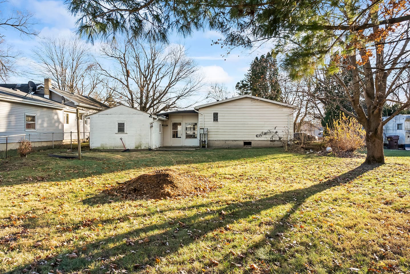 Spacious backyard with mature trees offering shade and privacy.