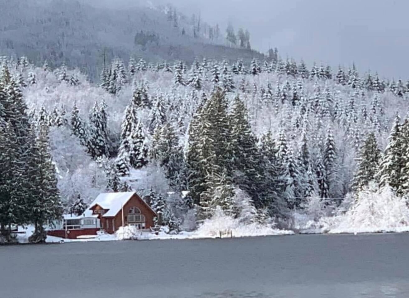 Calm winter lake with snow along the shoreline.