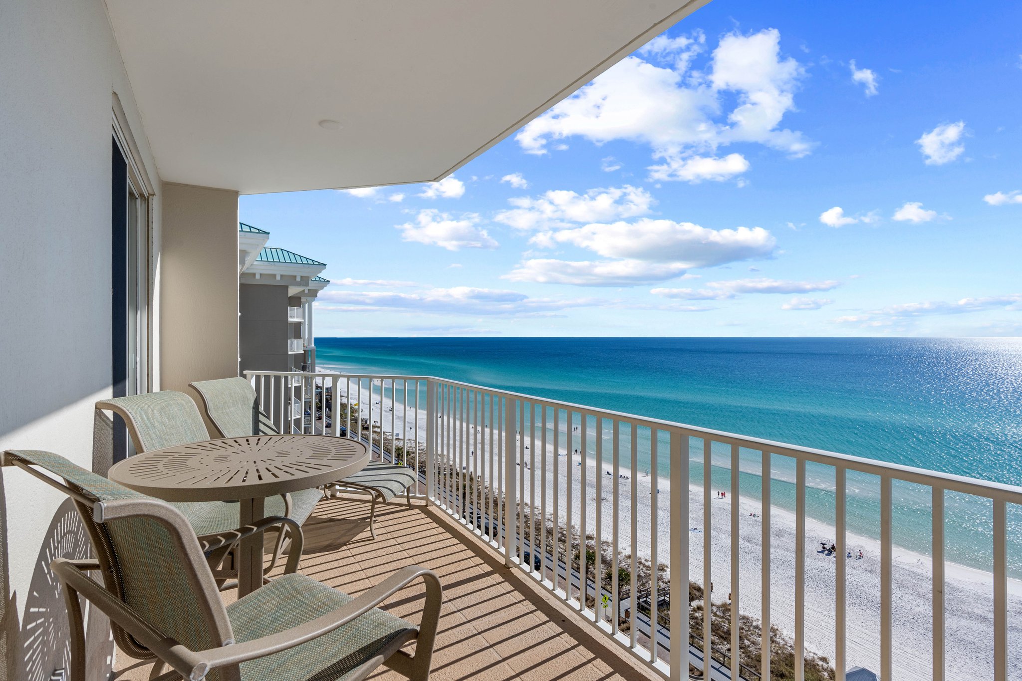Balcony setup w/ seating & sweeping ocean views just beyond the railing.