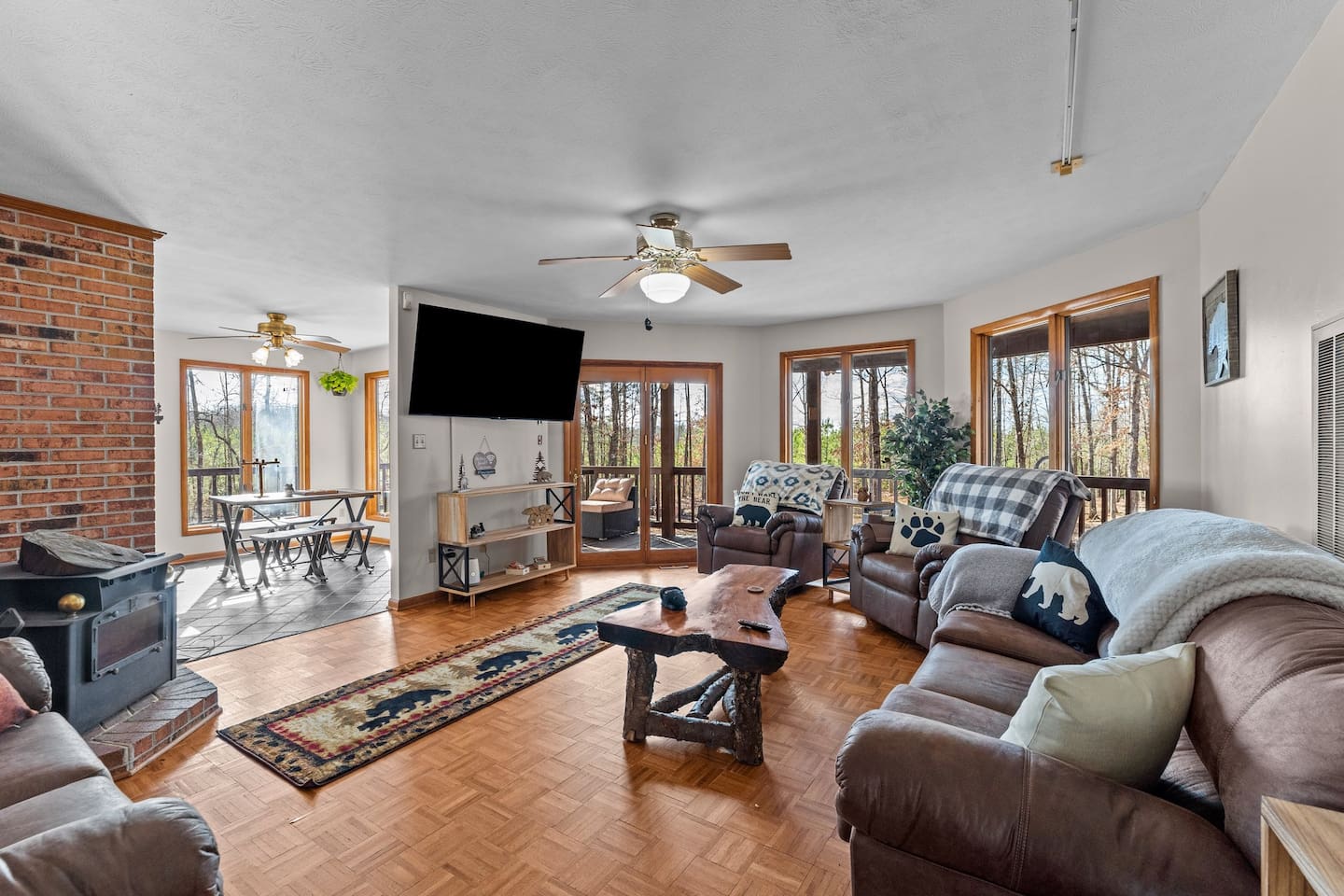 Living Room Retreat: Sunlit space with plush seating, rustic decor, and scenic forest views!