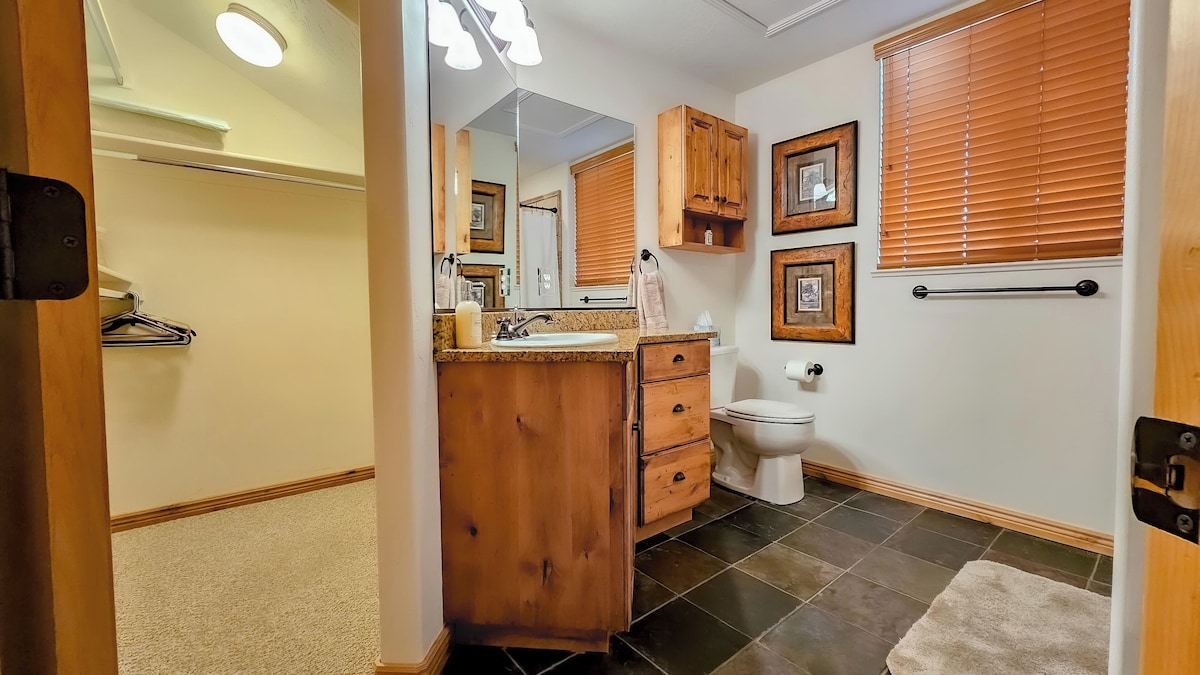 The primary bathroom features plenty of counterspace, ample storage, a hair dryer, and expansive mirrors.