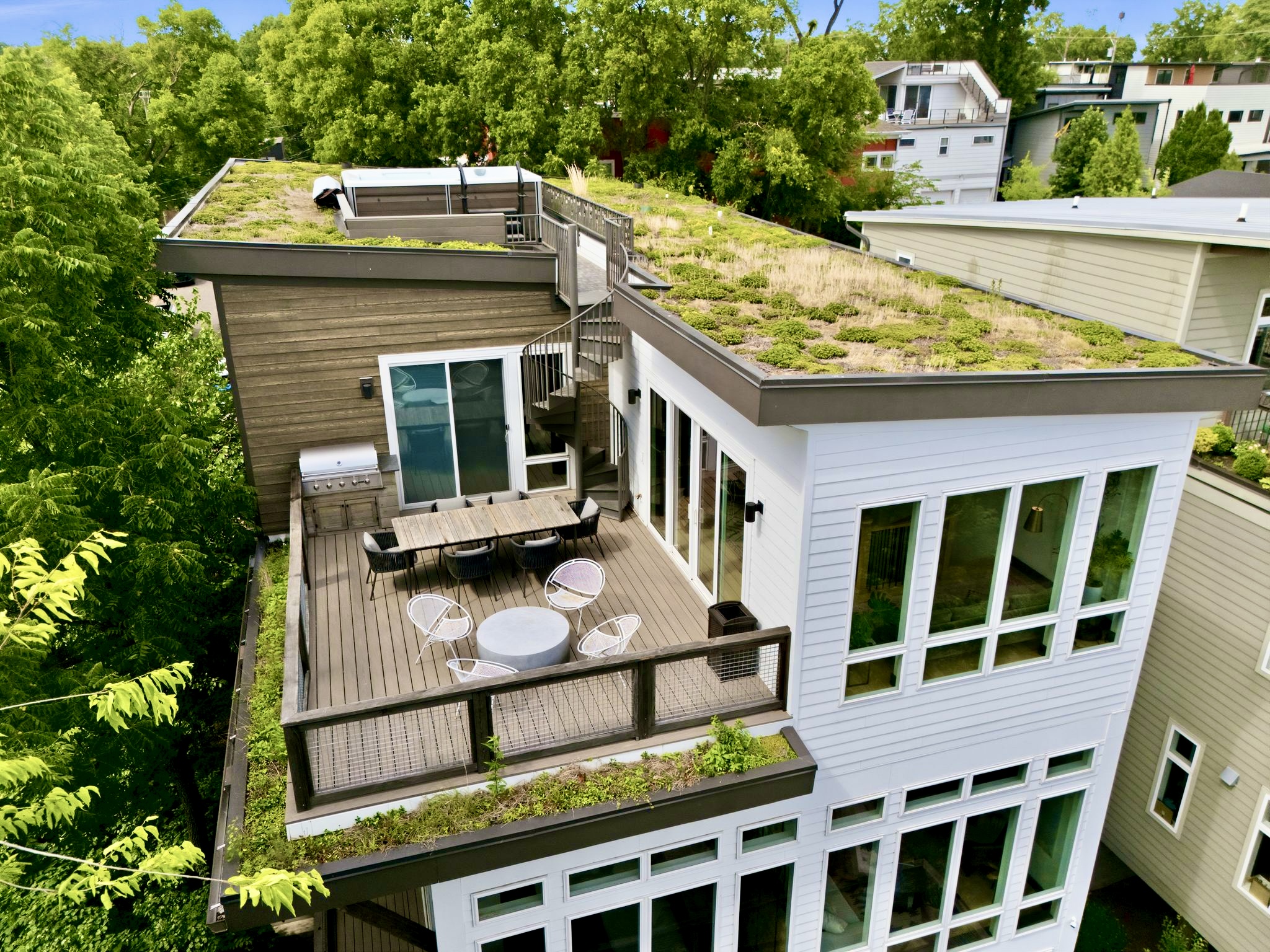 Aerial view of the home's rooftop terrace w/ seating nestled among a canopy of trees.
