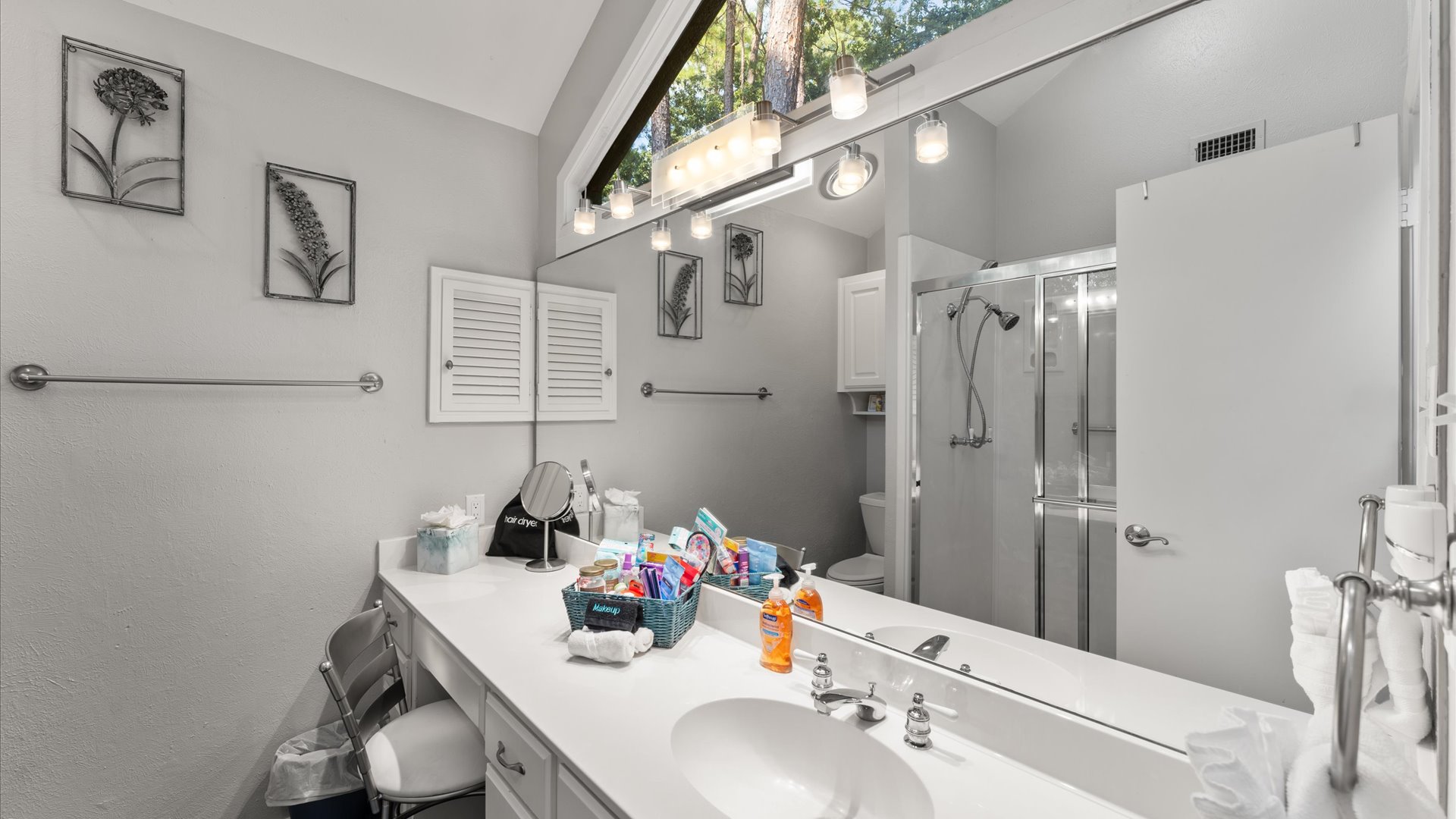 King 2 Bathroom features a walk-in shower, a thoughtful basket filled with essentials, and stunning views through its unique, eye-catching windows.